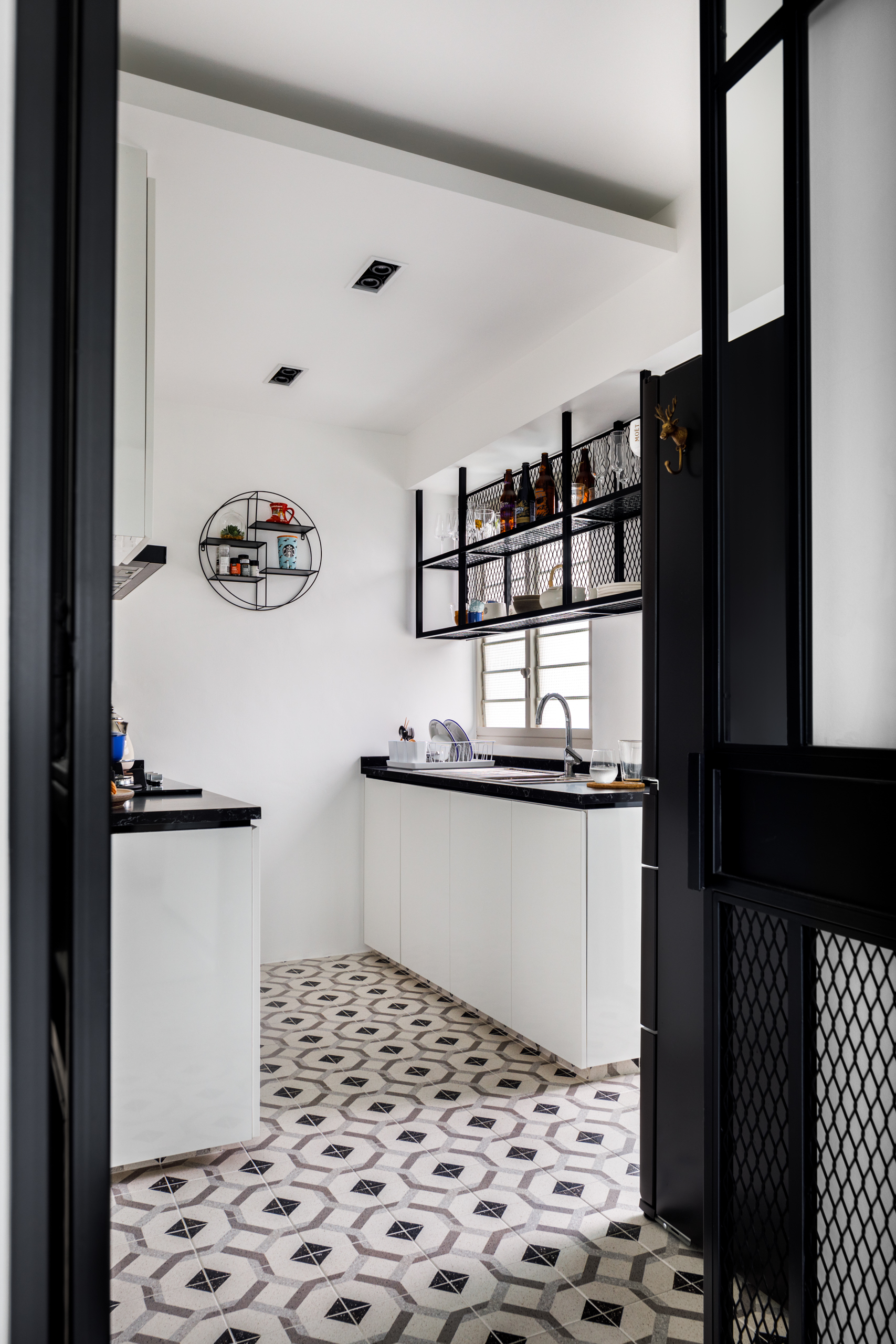 A Minimalist & Industrial Look For A Young Couple - Modern kitchen with black countertops and white cabinets, geometric