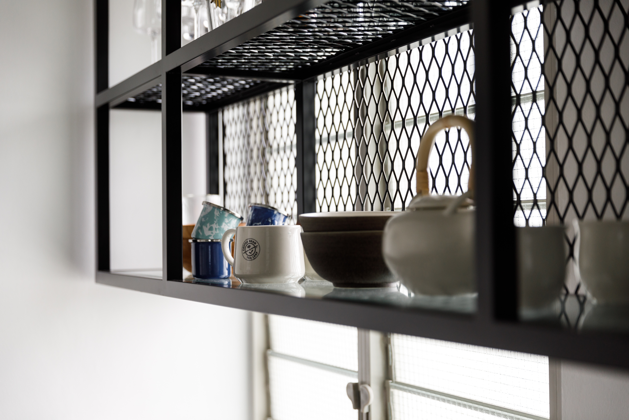 A Minimalist & Industrial Look For A Young Couple - Glass shelves, black metal frame, white ceramic mug, blue and white