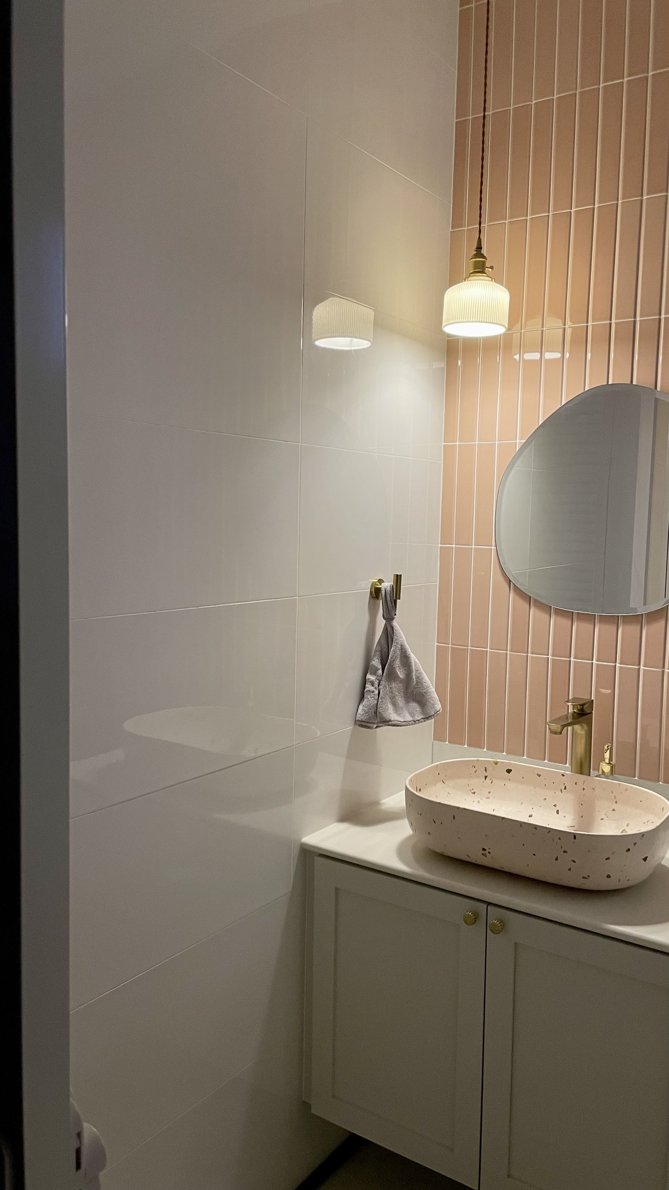Don’t turn on the big lights 💡 - Modern bathroom with minimalist design, white and peach color scheme, oval-shaped pink