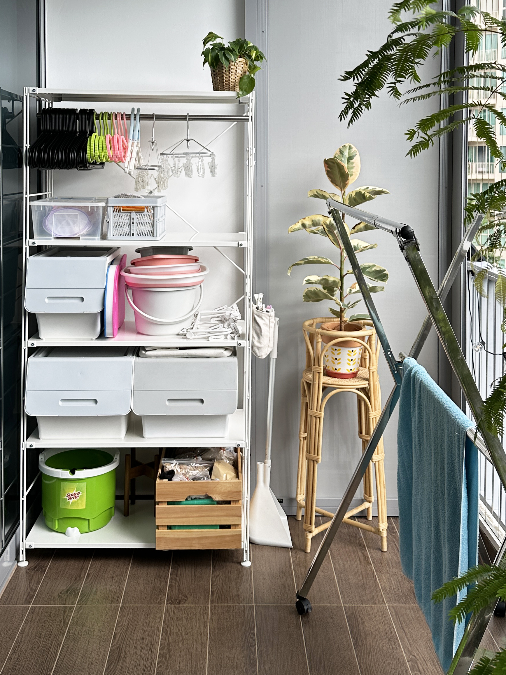 Our Sunny Laundry Haven  - Organized kitchen storage, multi-level shelving, white metal rack, hanging utensils, plastic