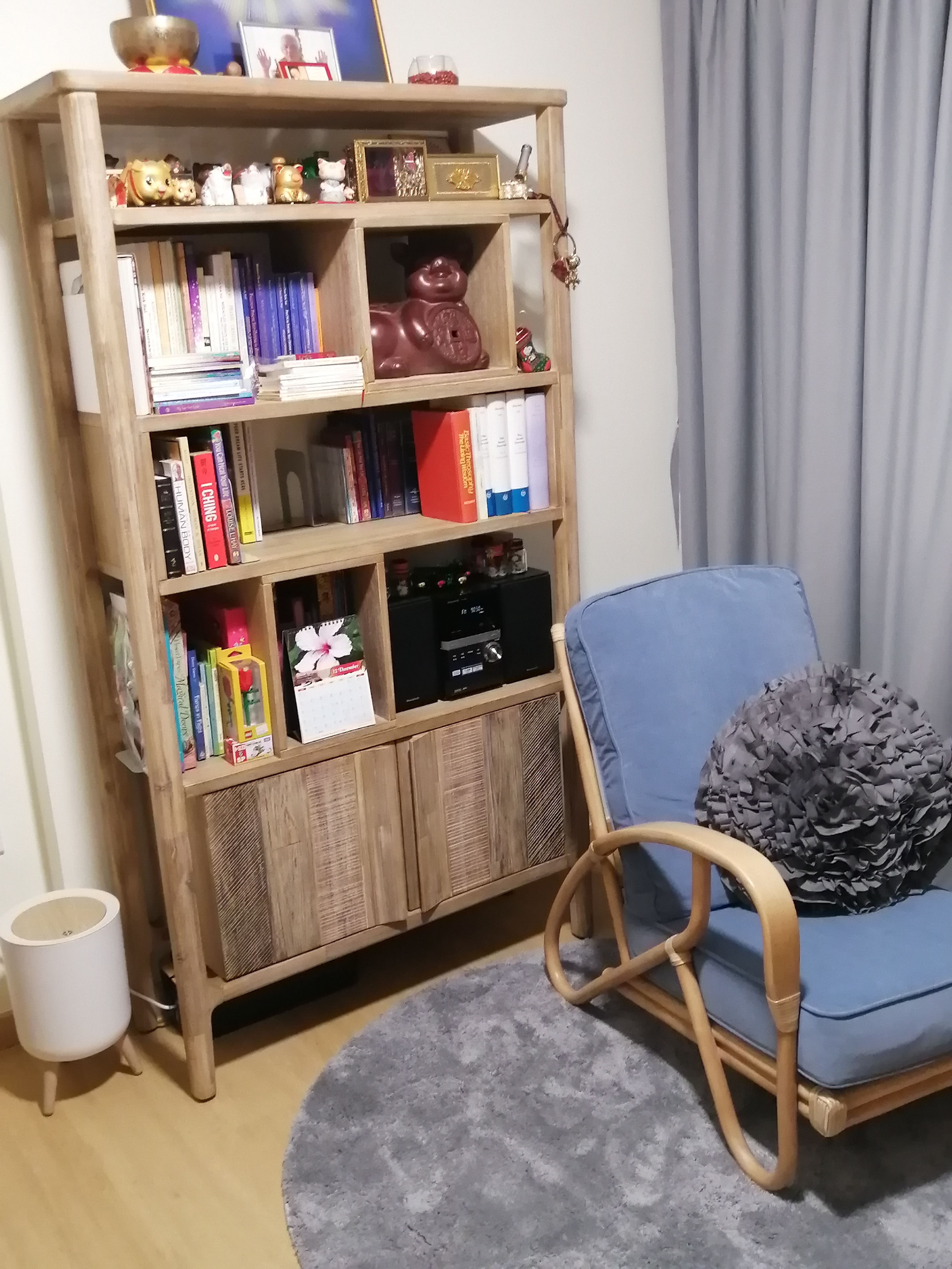 Eclectic Cosy Corner - Wooden bookshelf, books, decorative items, small figurines, framed pictures, red decorative bowl, blue