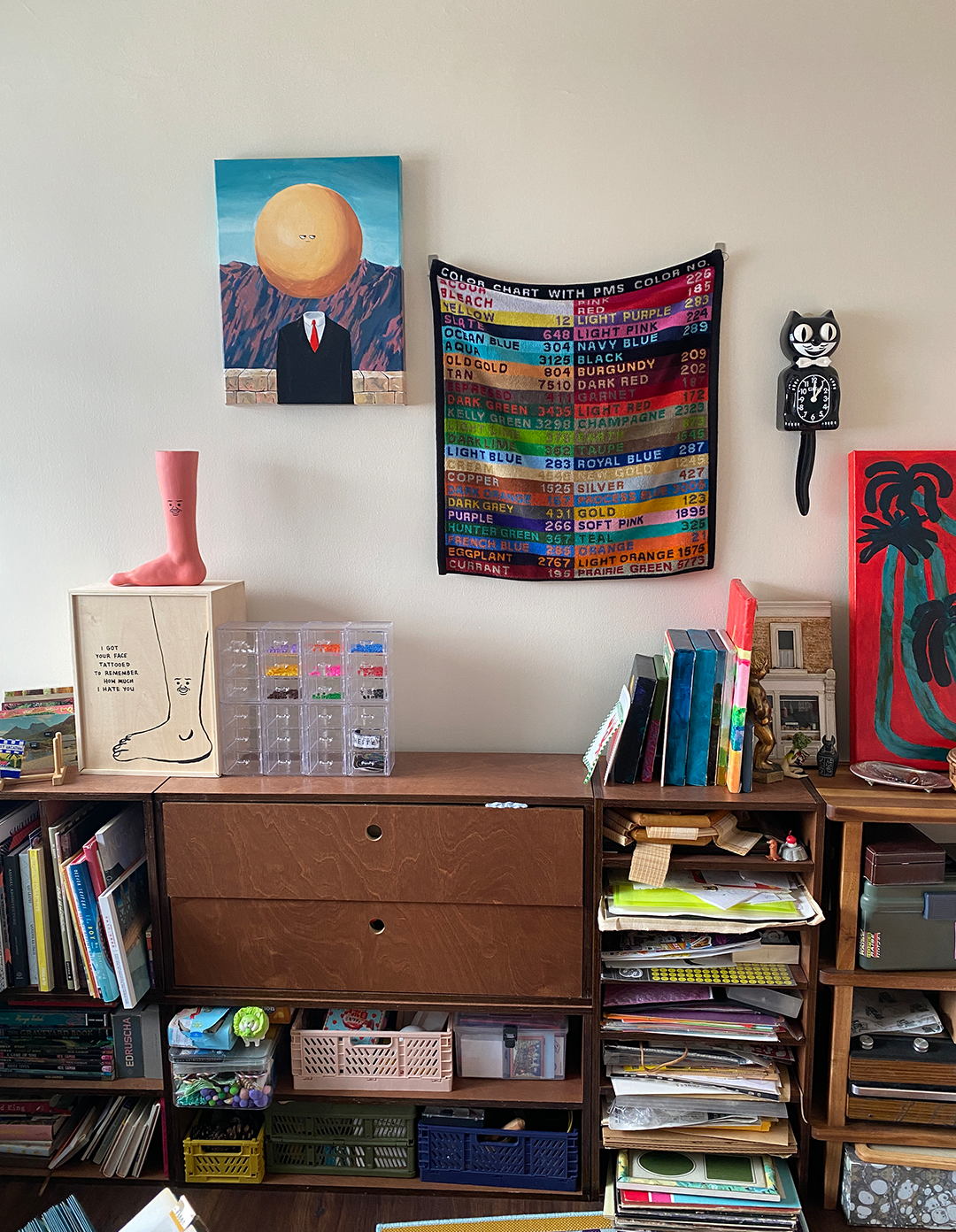 Navigating DIY Interior Design - Colorful tapestry hanging on a white wall, featuring a large yellow sun with a face., A