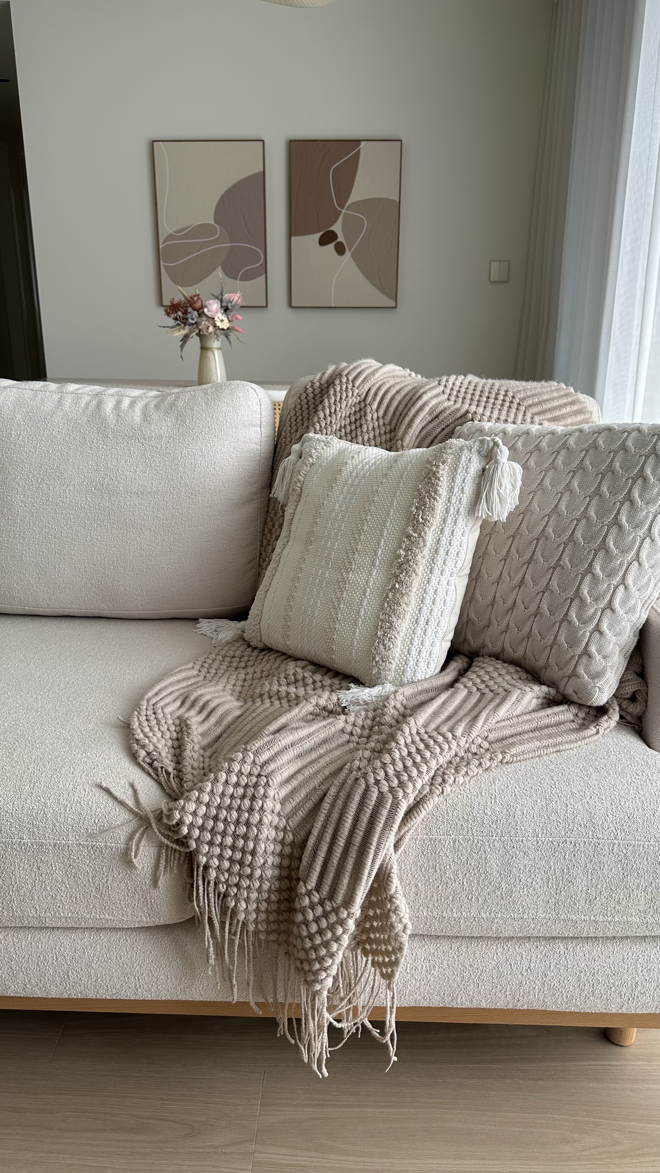 Our cozy corner for everyone at home  - Cream-colored sofa, beige textured blanket, decorative pillows, abstract art, light