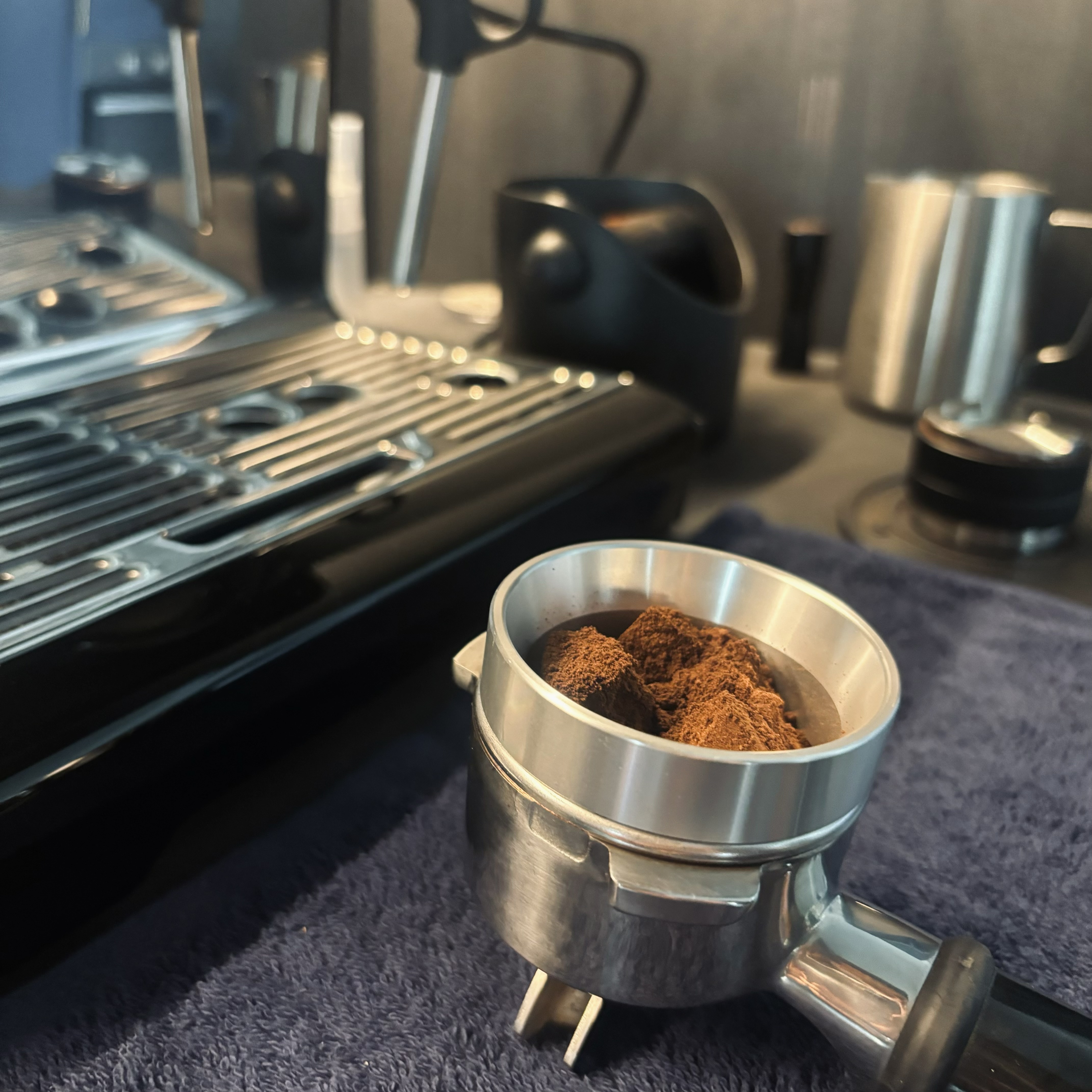 How to create a coffee nook in your home? - Mug filled with finely ground coffee, espresso machine, dark countertop