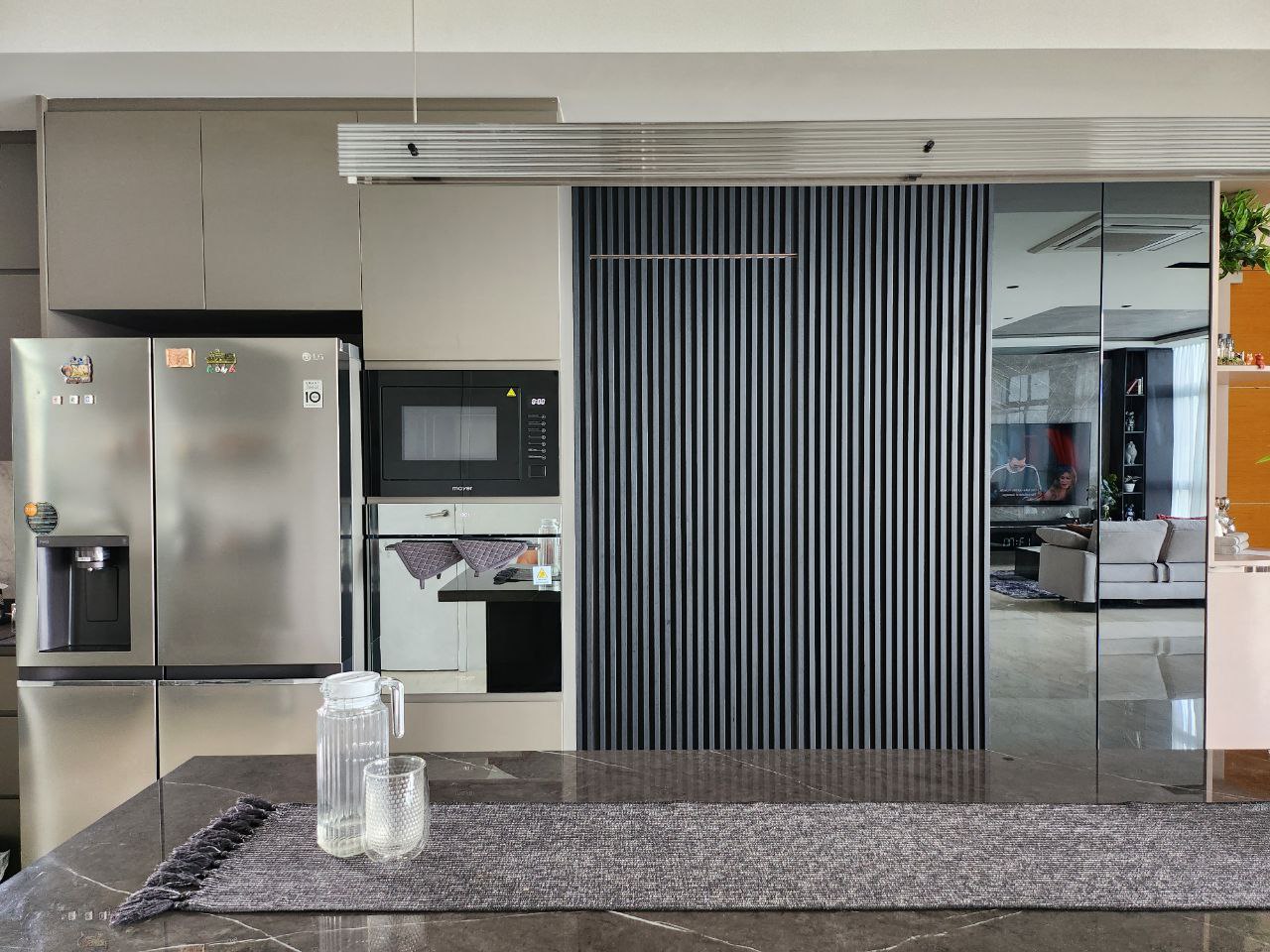 Bright and Airy Modern Home - Modern kitchen with sleek stainless steel appliances, including a refrigerator, microwave, and