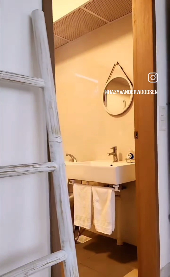 We saved $24400 from renovations & furnishing! - Bathroom interior, white sink, round mirror, wooden door frame, white