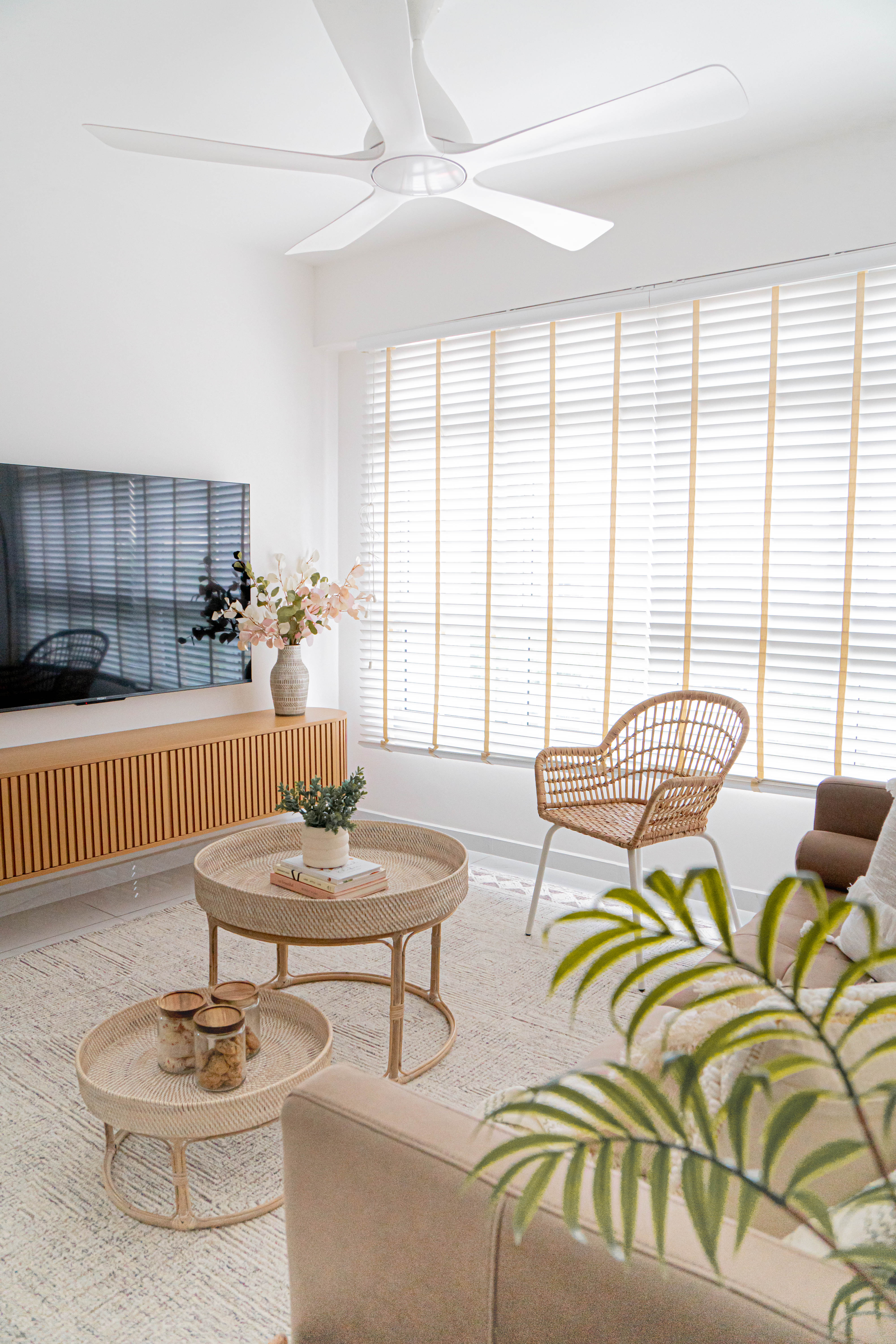 Japandi Living & Dining @ GreenFlora - Modern living room with large flat-screen TV, white ceiling fan, wooden entertainment