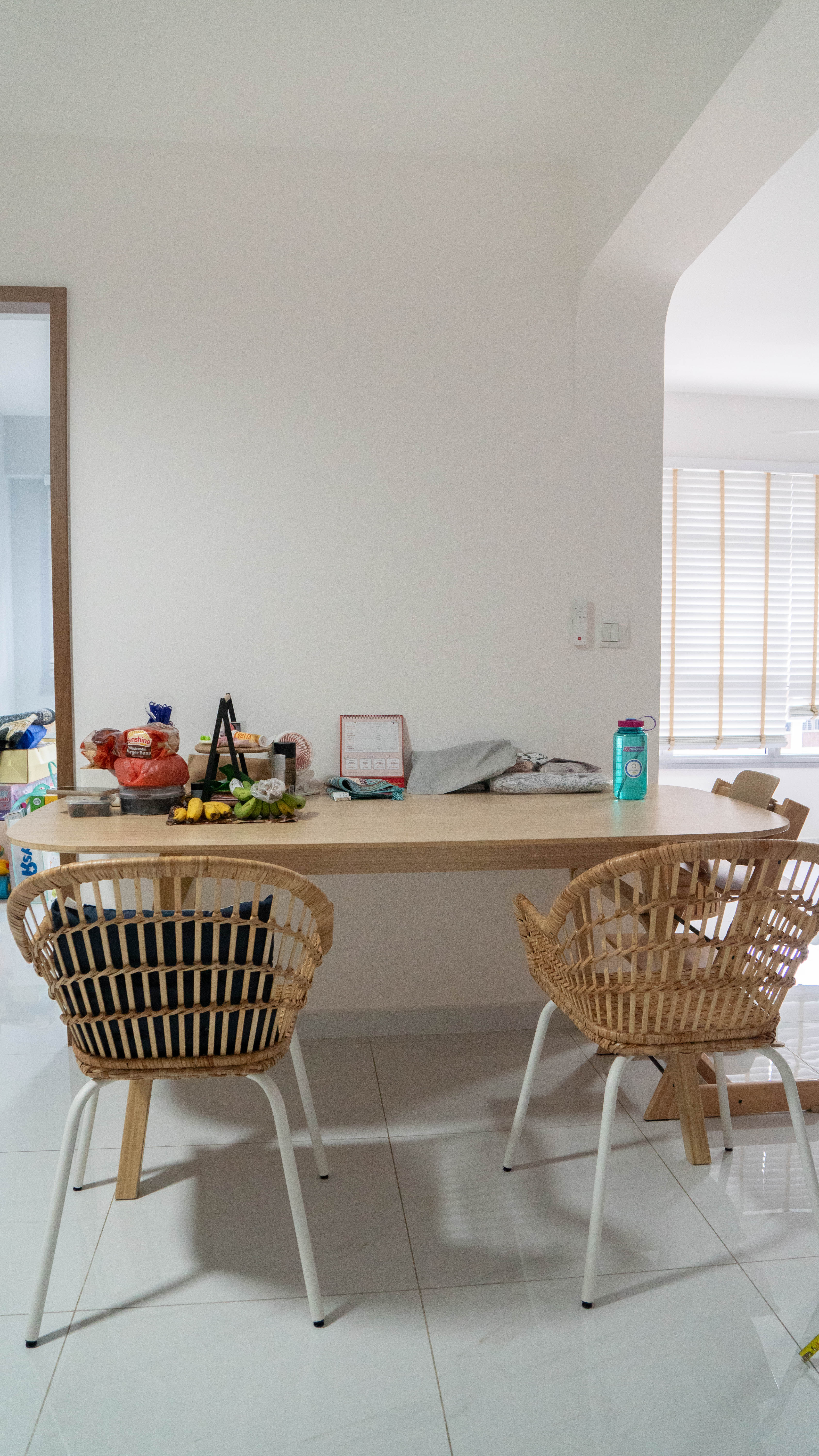 Japandi Living & Dining @ GreenFlora - Wooden dining table, two wicker chairs, white tiled floor, natural light, minimalist