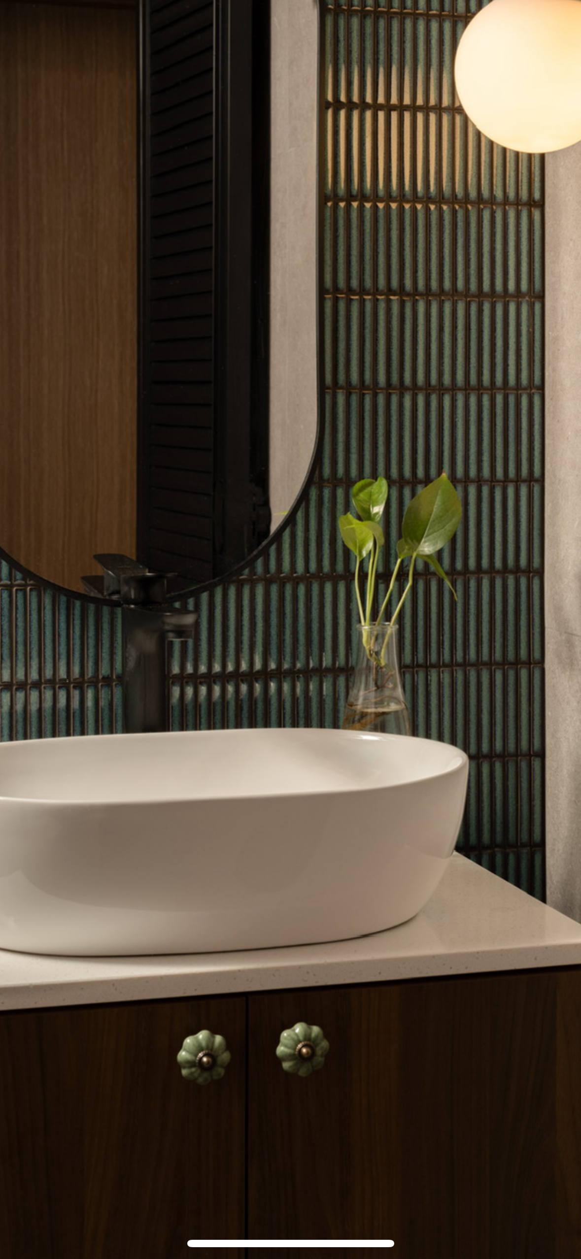 A mid-century modern home in the East - modern bathroom vanity, white oval sink, dark wooden cabinet, green decorative