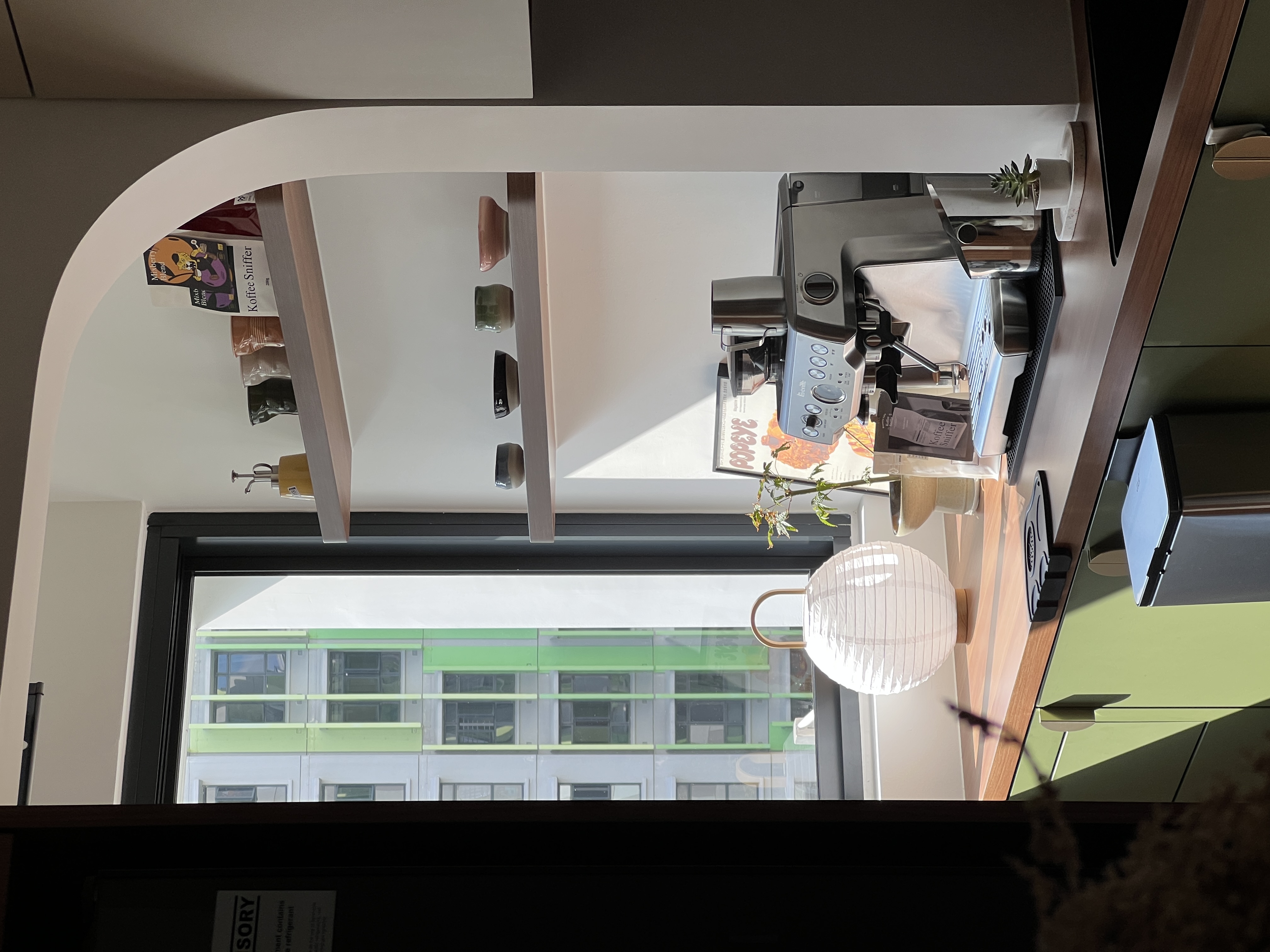 A mix of everything, with a bit of everything.  - Modern kitchen workspace, sleek coffee machine, minimalist decor, natural