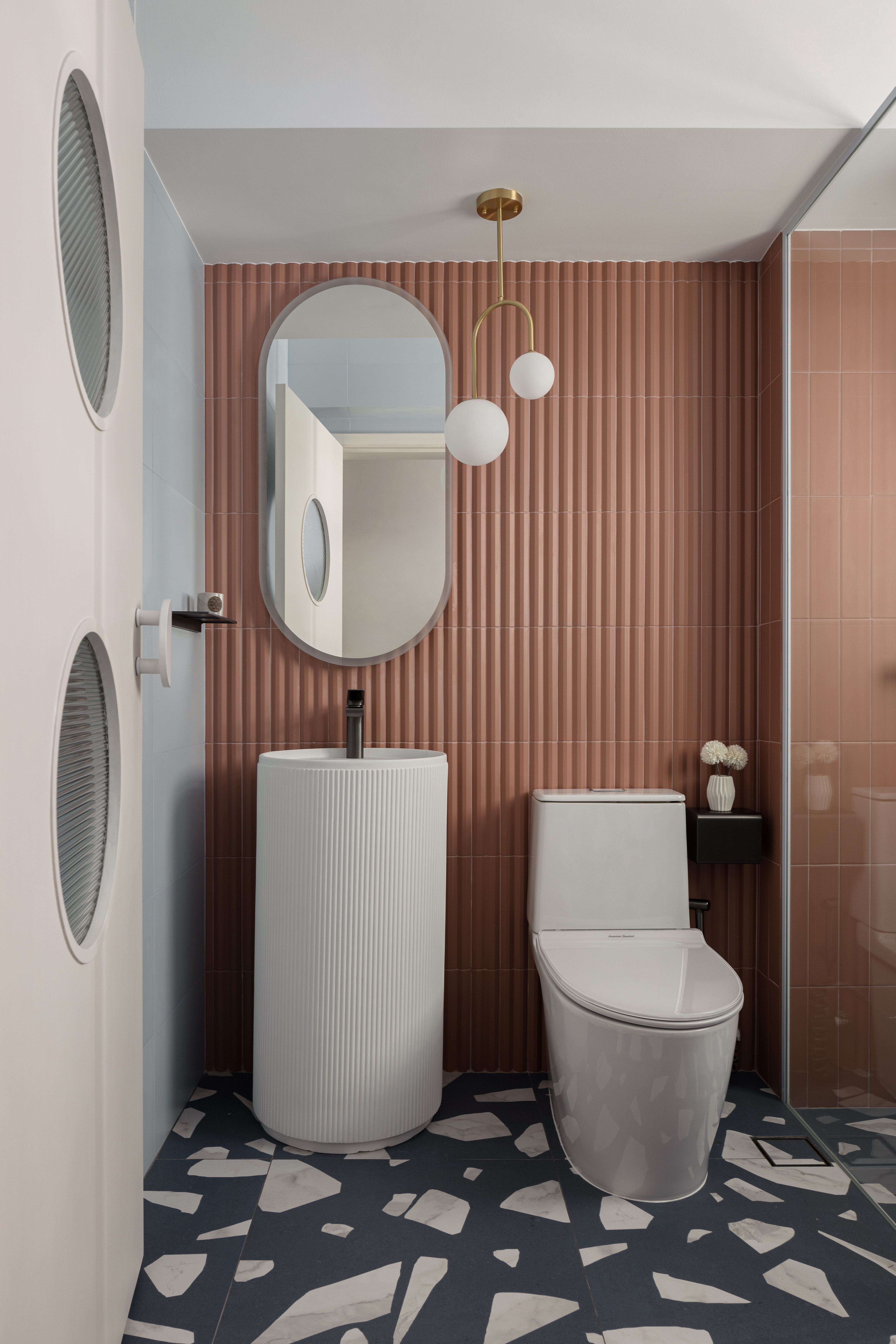 A mix of everything, with a bit of everything.  - Modern bathroom with sleek design, white toilet, circular mirror, brown