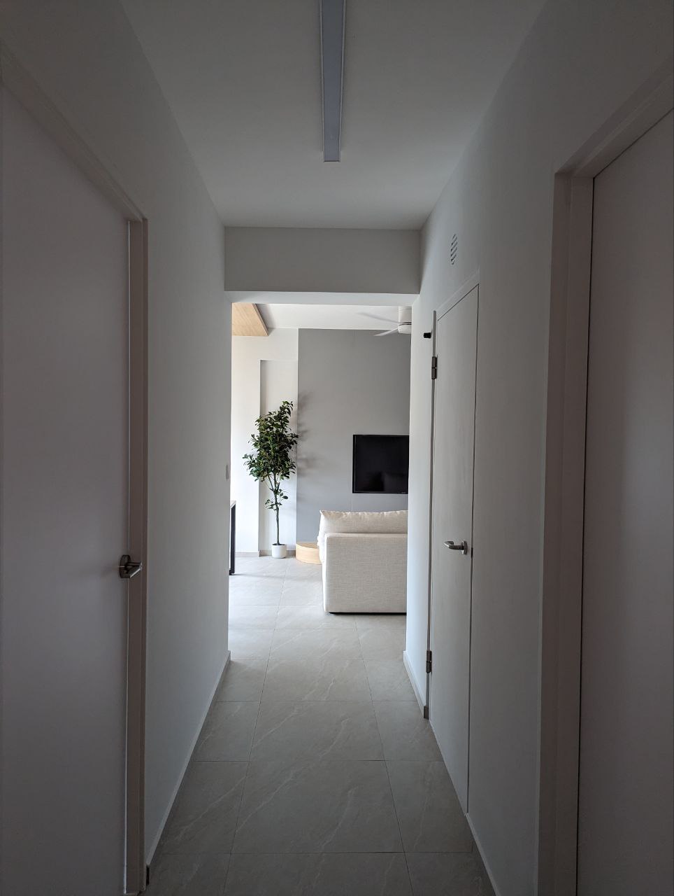 Building our own home quite literally - Modern minimalist living room, sleek white walls, tiled floor, open doorway