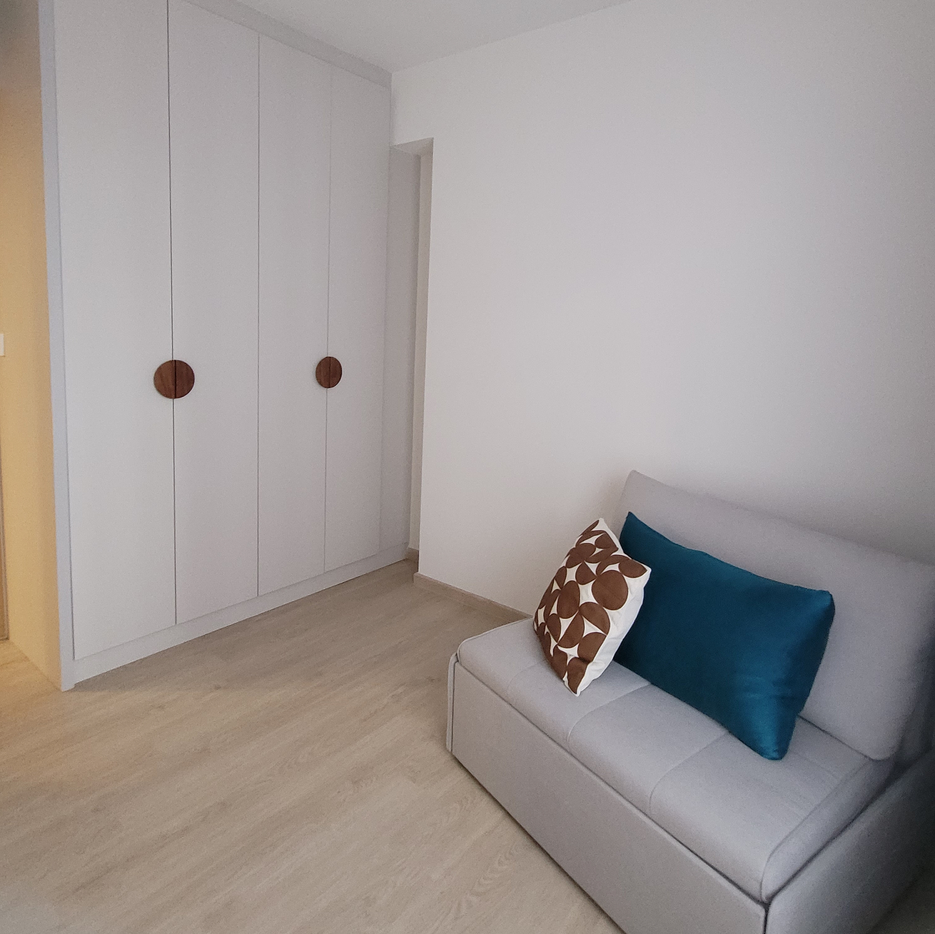 Step into our Modern Farmhouse with pops of Disney - White minimalist wardrobe with round wooden handles, light wooden floor