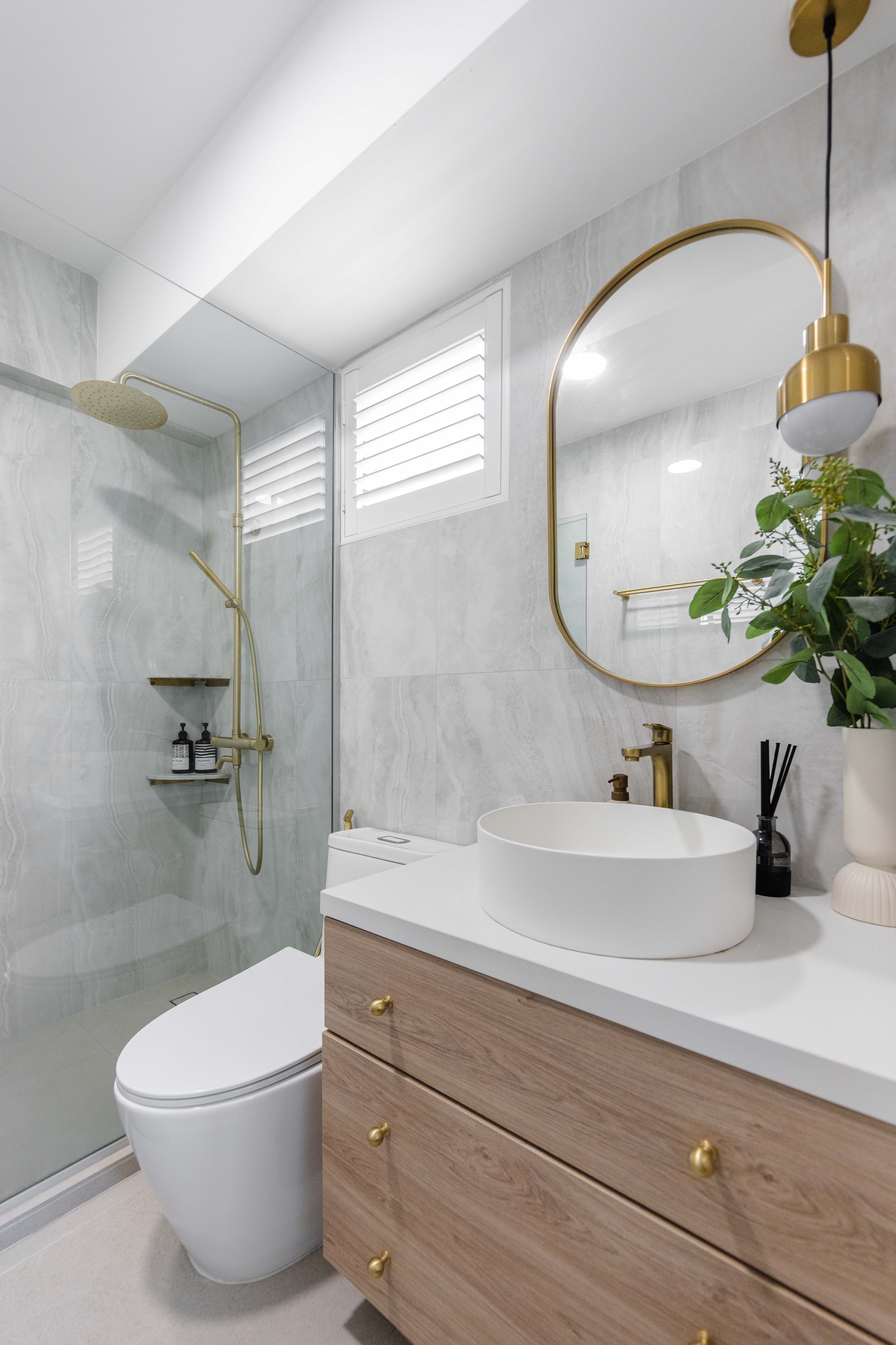 Bright, Airy & Curvy! - Modern bathroom with sleek design, white marble tiles, gold fixtures, white toilet, glass-enclosed