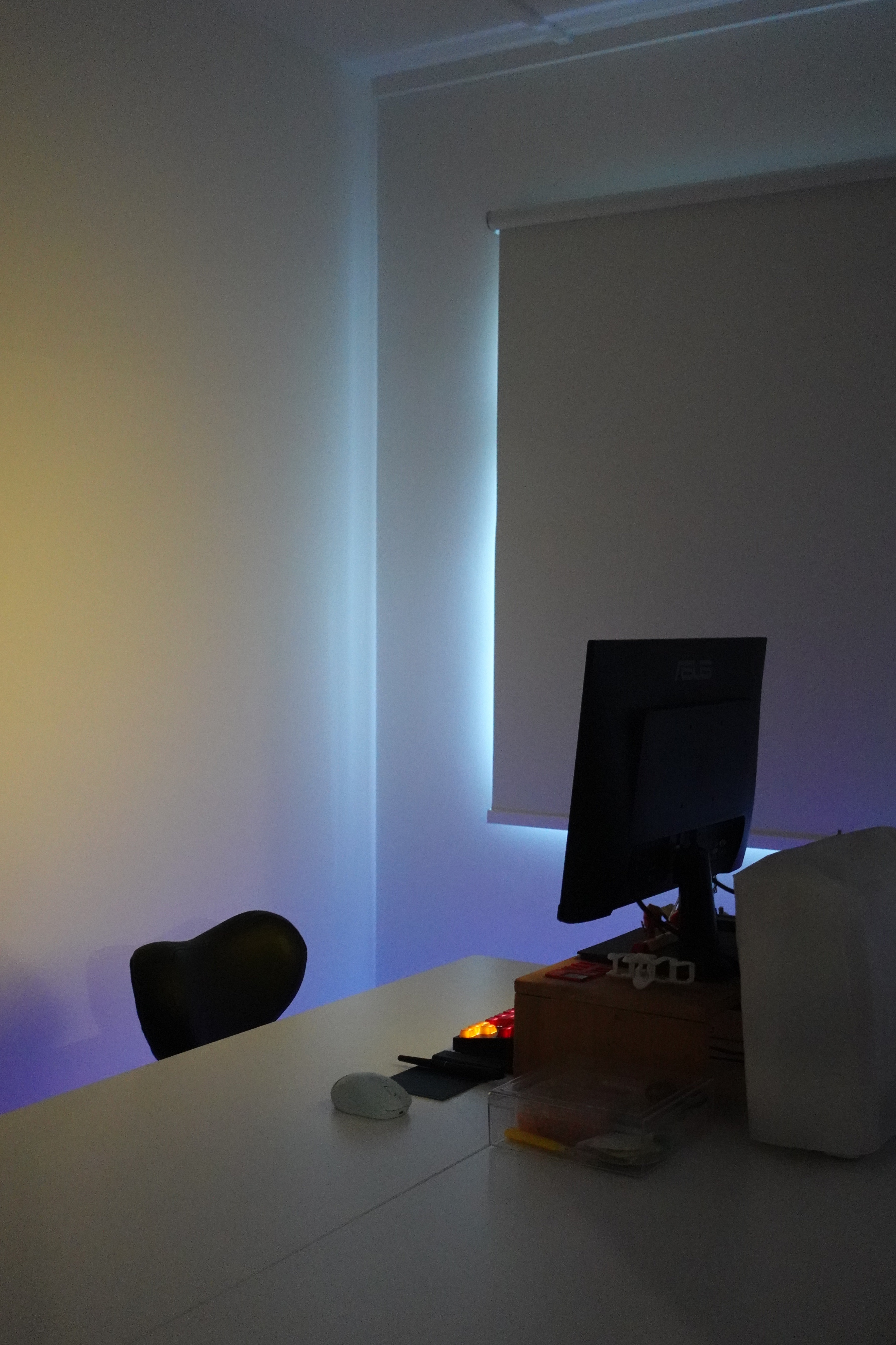 O hey there, welcome to our "minimalist" home   - Modern minimalist workspace, sleek black chair, illuminated desk, ambient