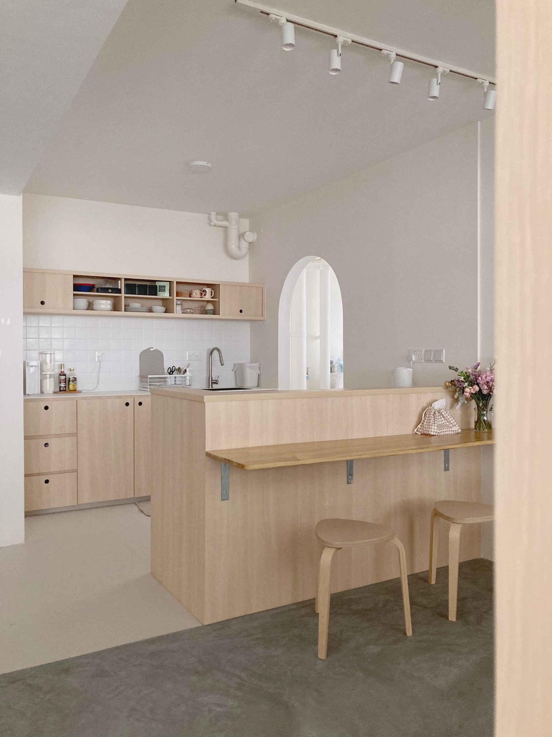 Warm Minimalist open-concept home - Light wood kitchen cabinetry, minimalist design, open shelving, white tiled backsplash