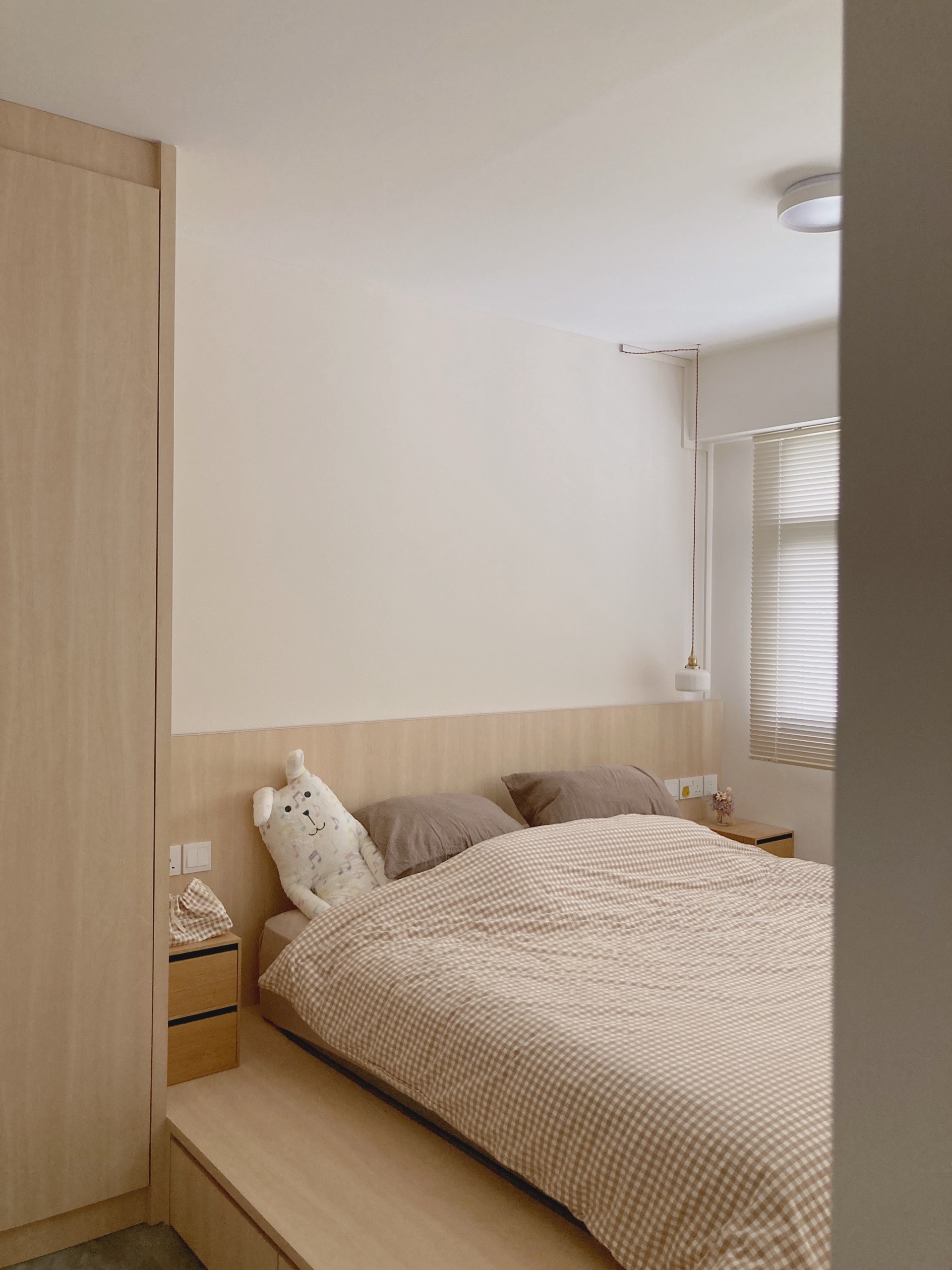 Warm Minimalist open-concept home - Wooden wardrobe, minimalist design, cozy bed, checkered bedspread, plush teddy bear