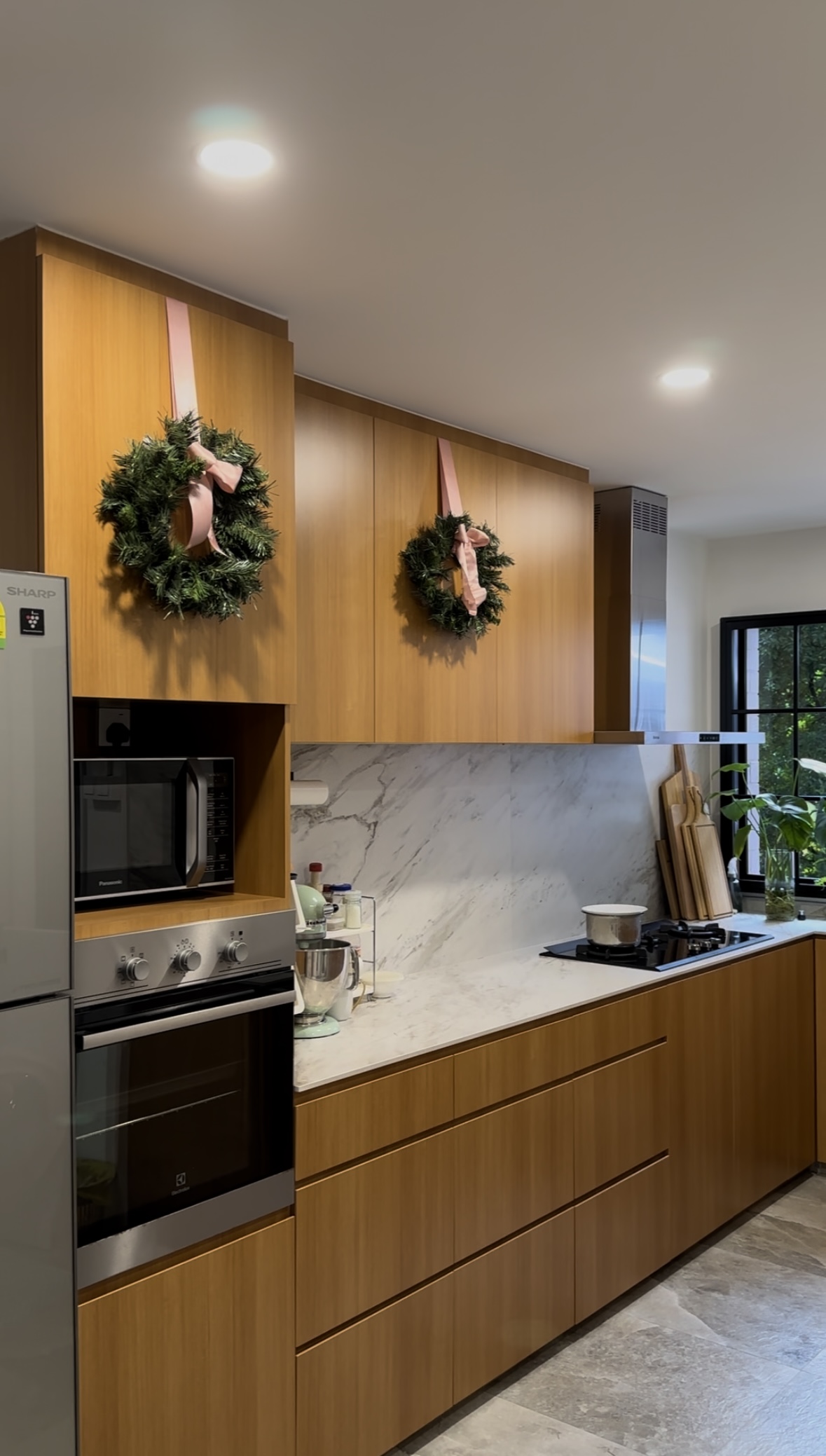 Our Home's Holiday Glow-Up with Crystal Sparkles and Pretty in Pink - Wooden kitchen cabinetry, modern appliances, marble