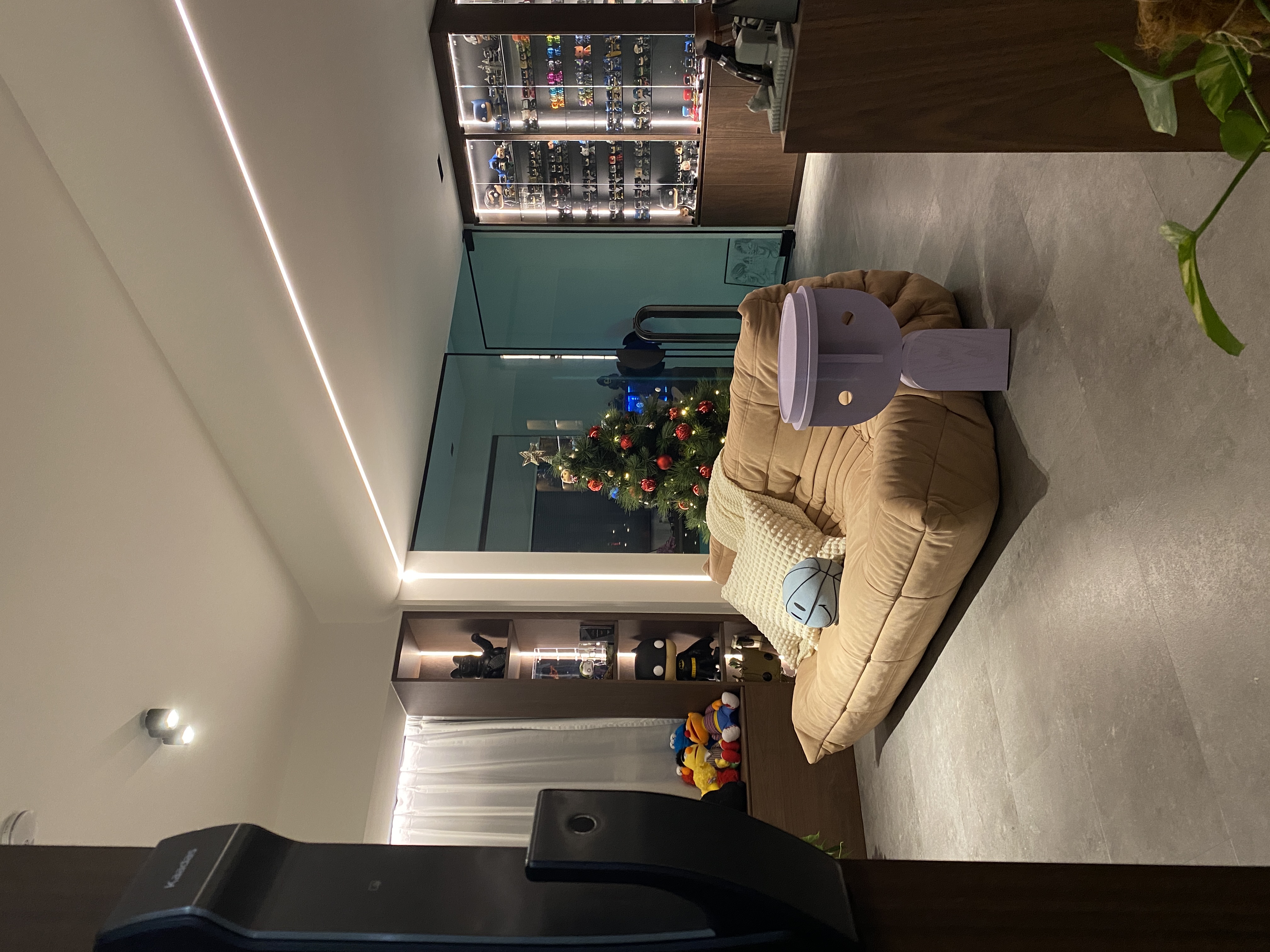 This the season to be jolly - Modern living room, cozy seating, plush beige bean bag, festive Christmas tree, soft lighting