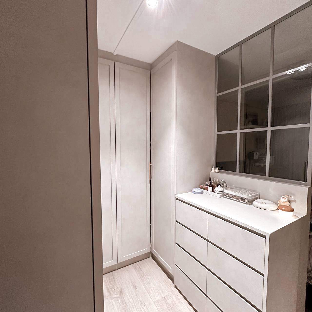 Bedroom Essentials - Light-colored, minimalist bathroom with sleek cabinets, modern vanity featuring a large mirror, soft
