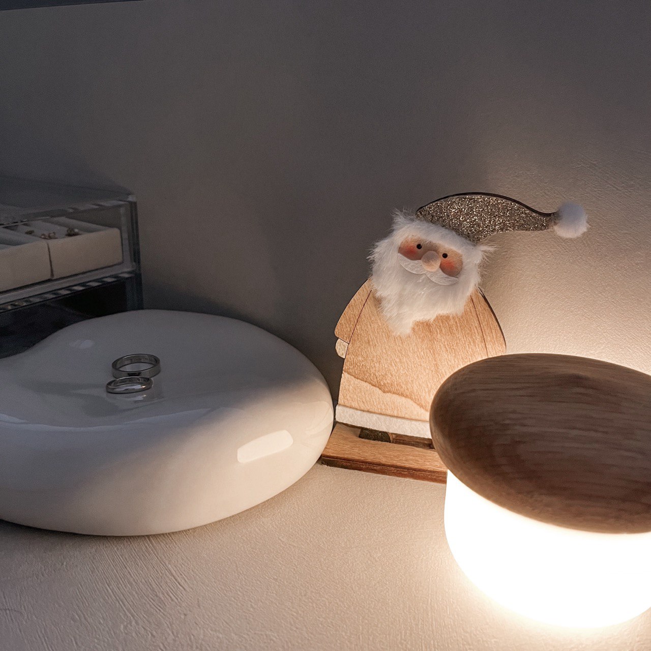 Bedroom Essentials - White oval sink, wooden stool, Santa Claus figurine, glittery hat, soft lighting, cozy corner, plush