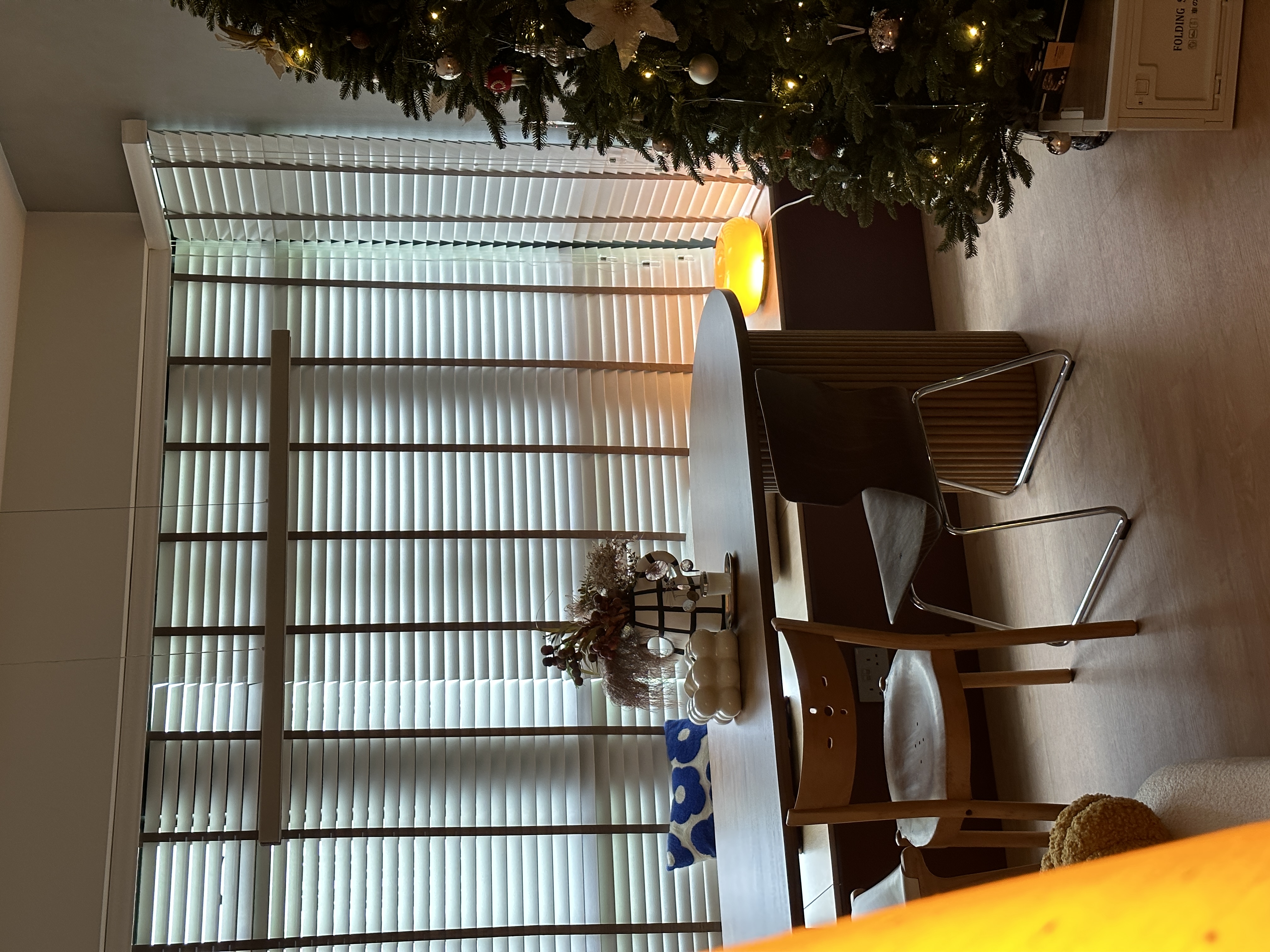 A cozy dining space right at the window bay!  - Christmas tree adorned with lights and ornaments, large window with blinds