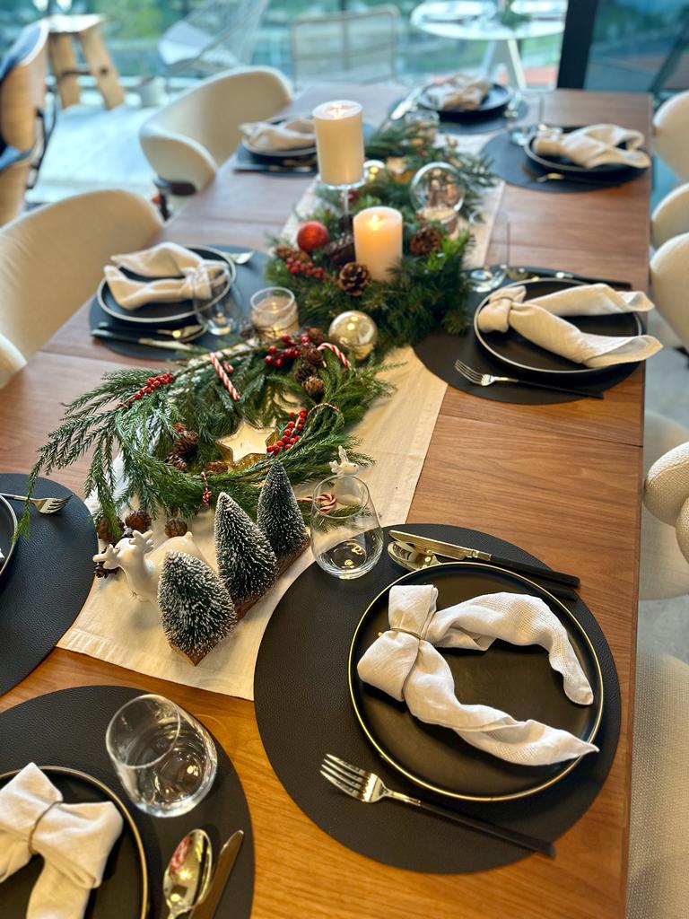 Our dining room goal - Christmas-themed dining table, festive decorations, black plates with white napkins, clear glass