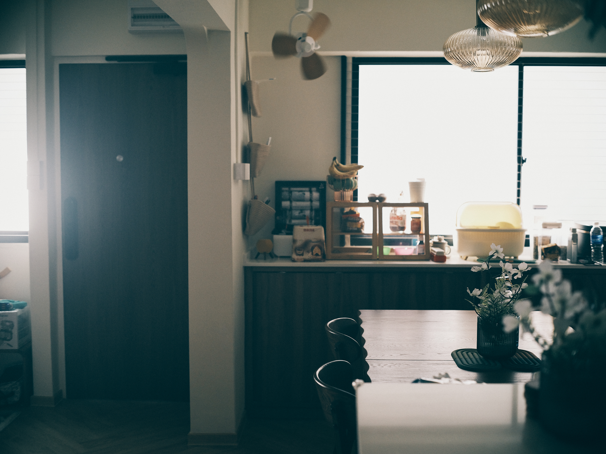 A mid-century family dining area - kitchen, dining area, dining table, wooden furniture, chairs, potted plant, window