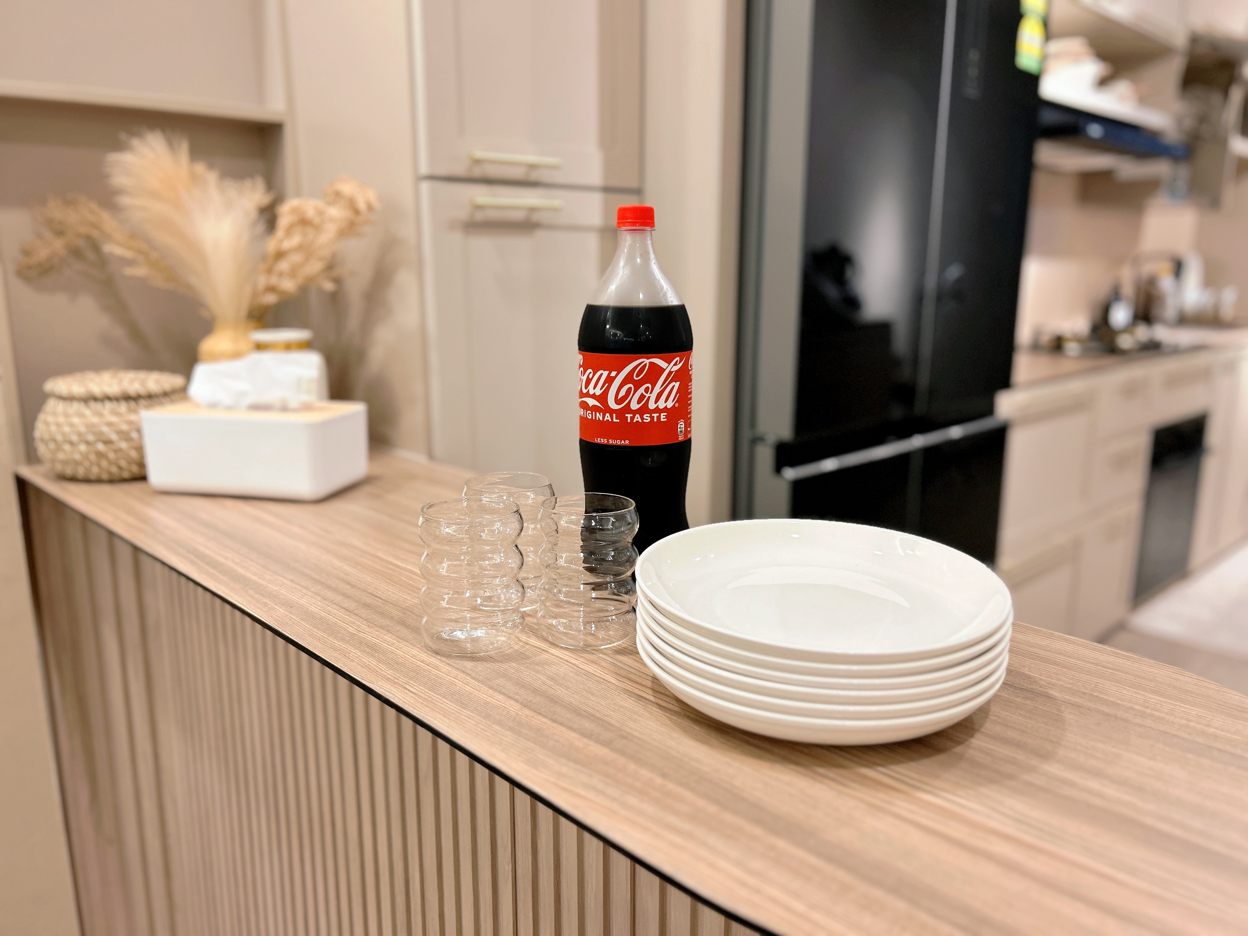 Welcome to Marshy Home! - Coca-Cola bottle, glassware, white plates, wooden countertop, modern kitchen, minimalist decor