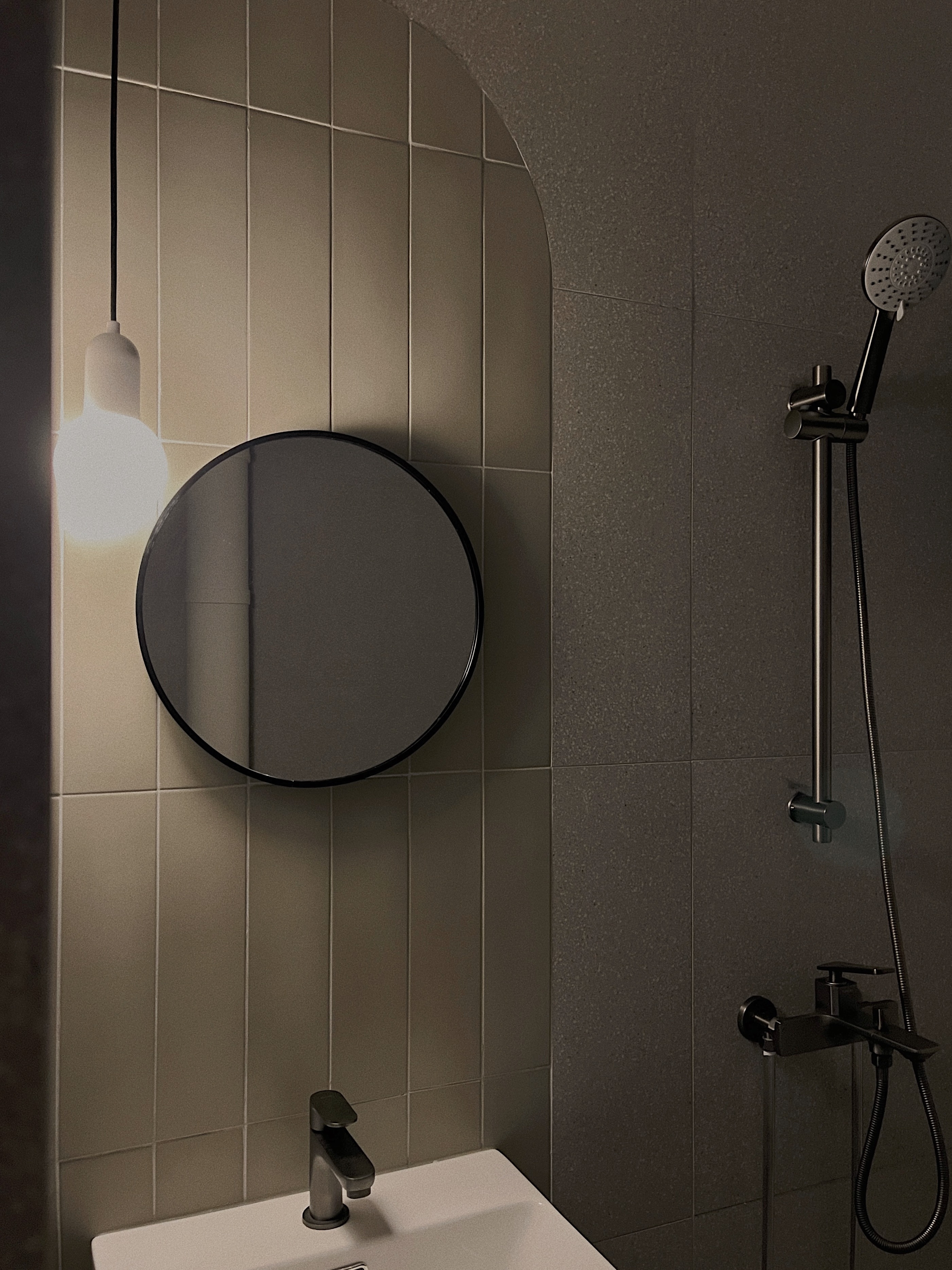 A calm and cosy space - Modern bathroom, minimalist design, sleek fixtures, round mirror, black accents, contemporary decor