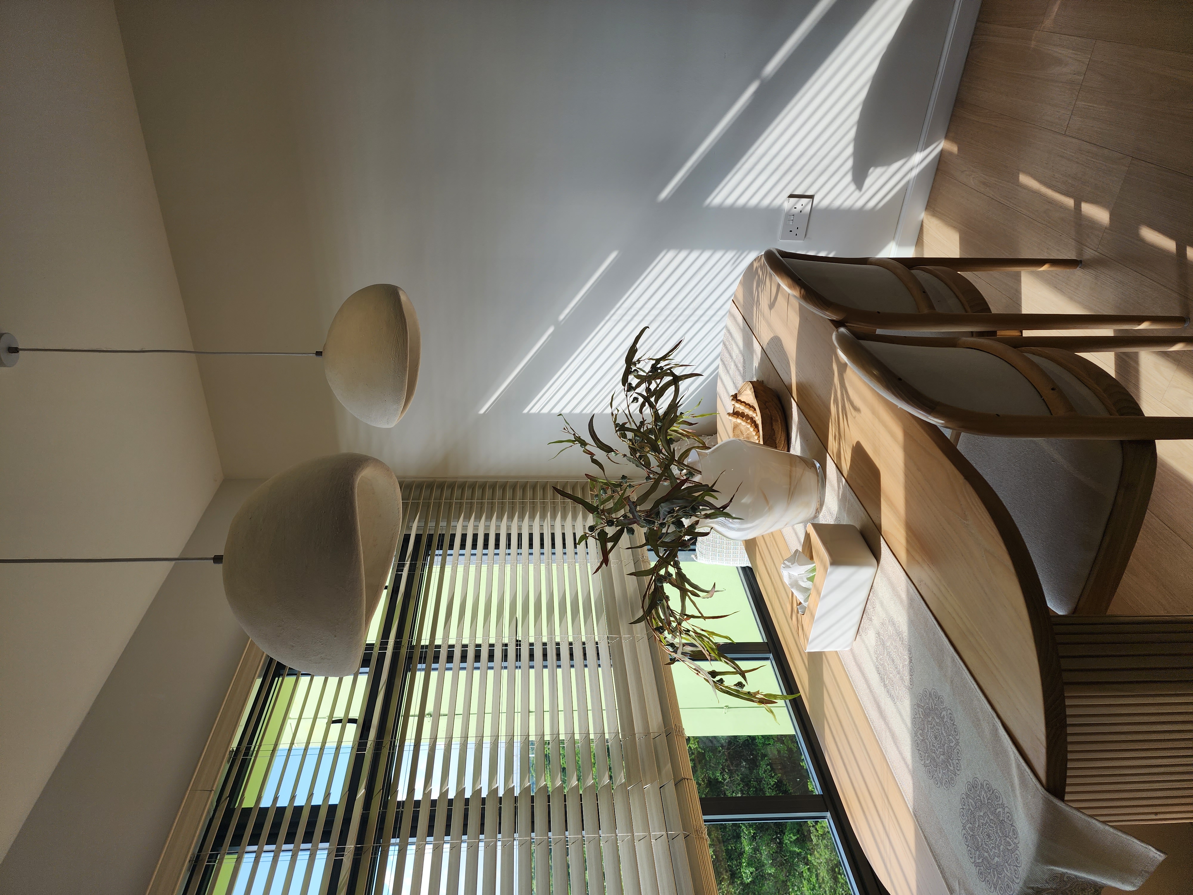 Dining Space - Embracing The Curves  - sunlight streaming through blinds, modern ceiling light fixture, wooden floor