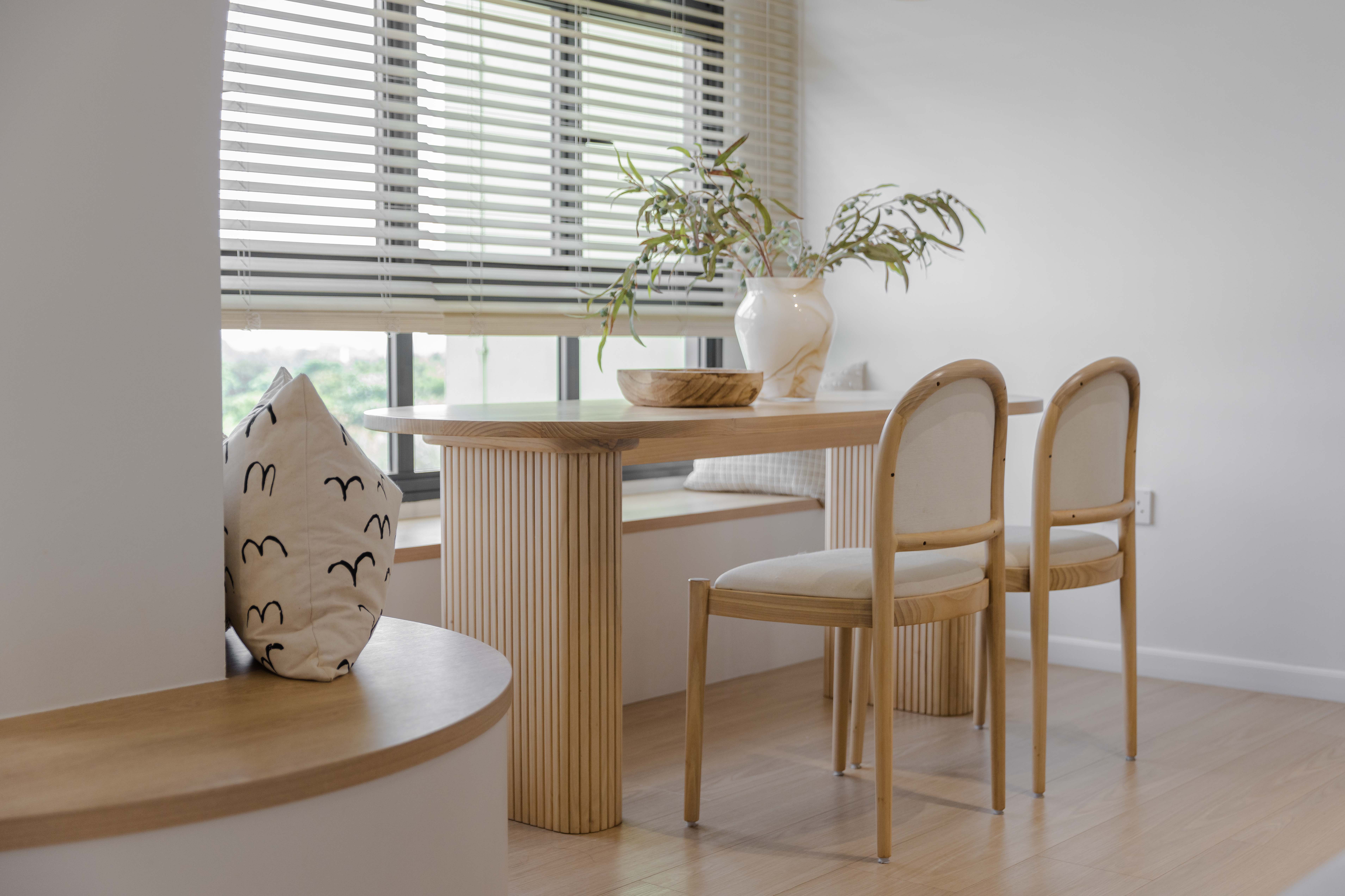 Dining Space - Embracing The Curves  - Modern minimalist dining room, natural light streaming through window, wooden table