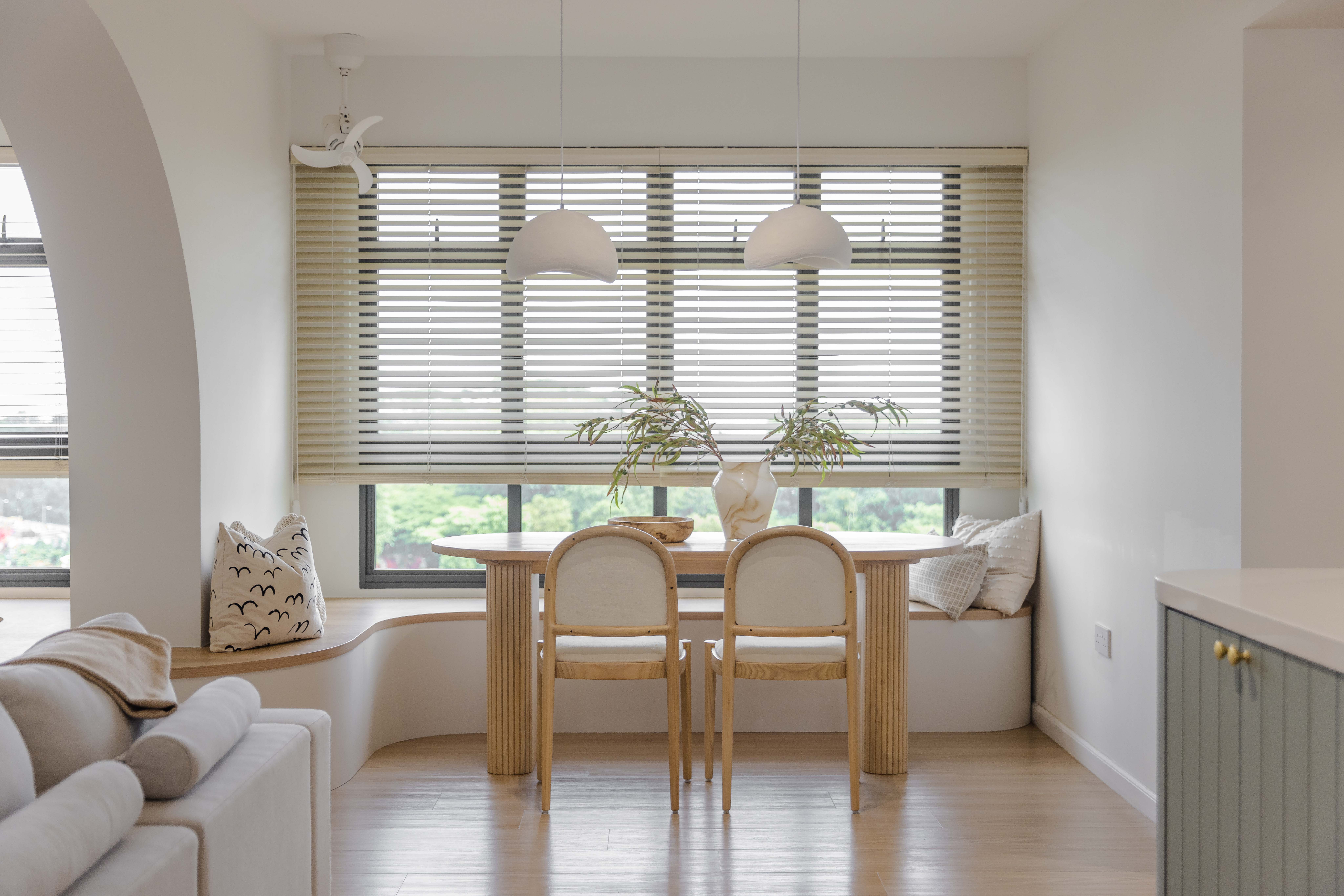 Dining Space - Embracing The Curves  - Modern minimalist dining room with white walls, wooden floor, and large windows with
