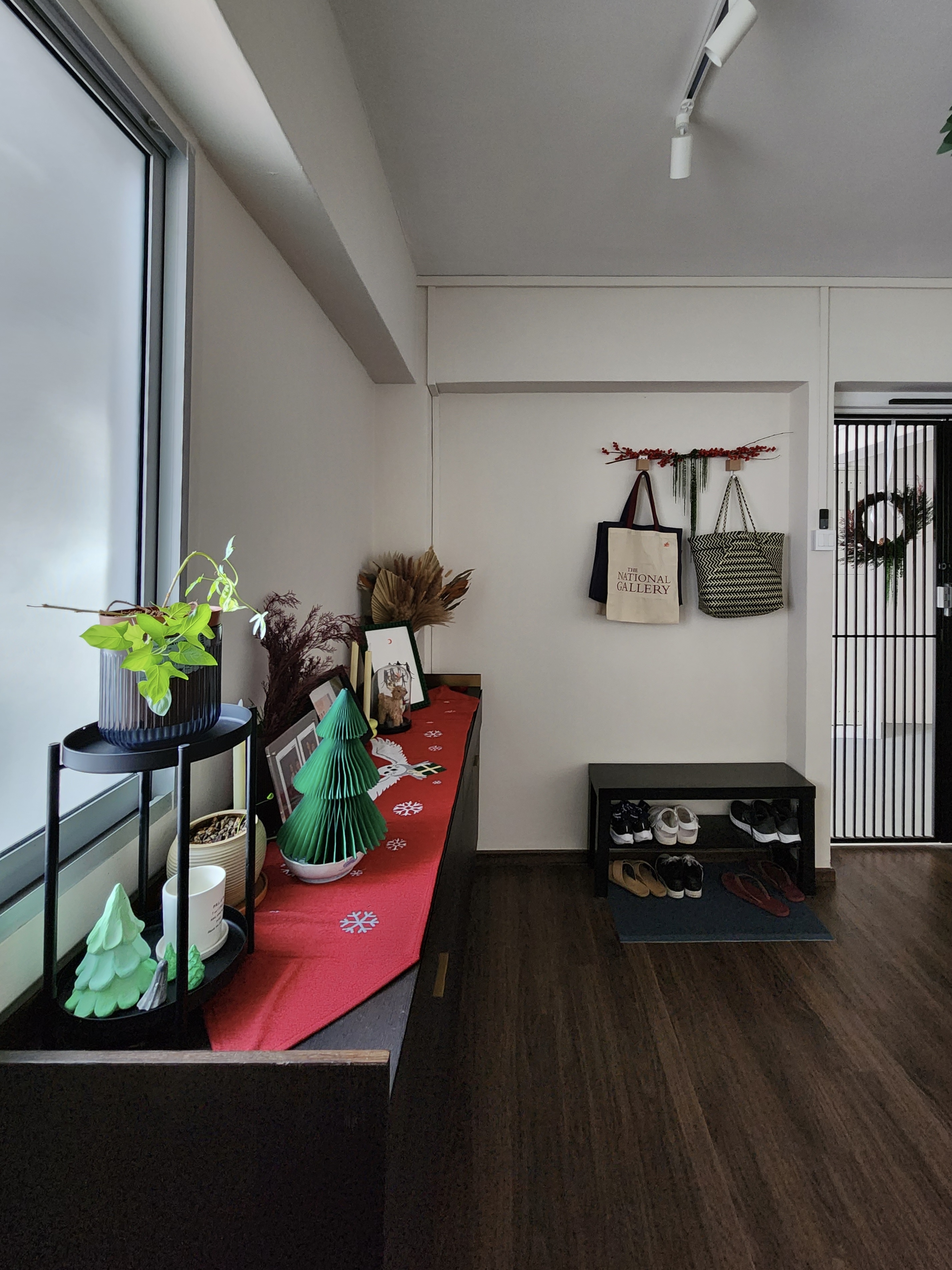A maximalist Christmas set-up with DIY touches! - window sill, green plant, red tablecloth, festive decorations, black shelf