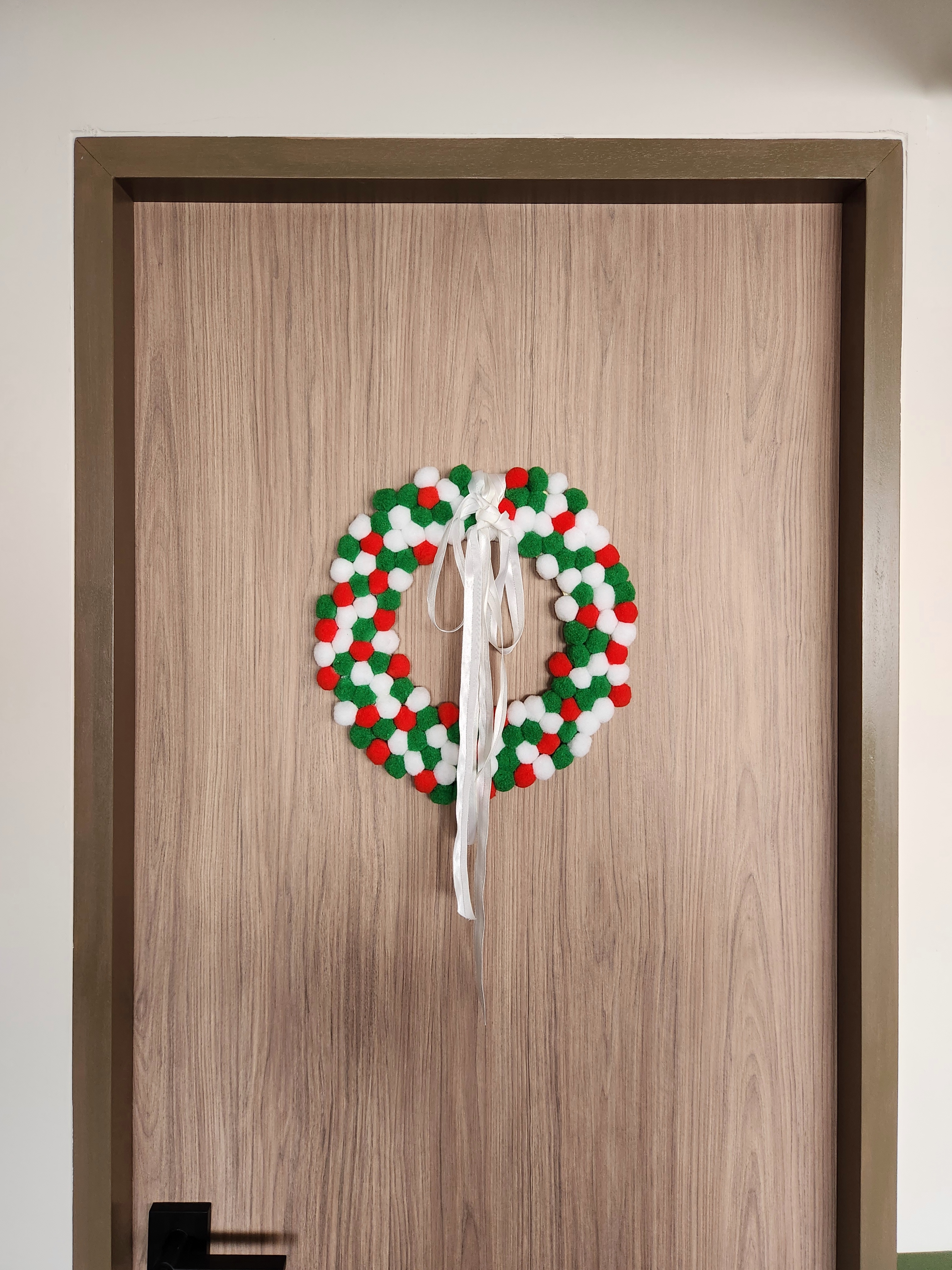 A maximalist Christmas set-up with DIY touches! - Christmas wreath, wooden door, festive decoration, green and red pom-poms