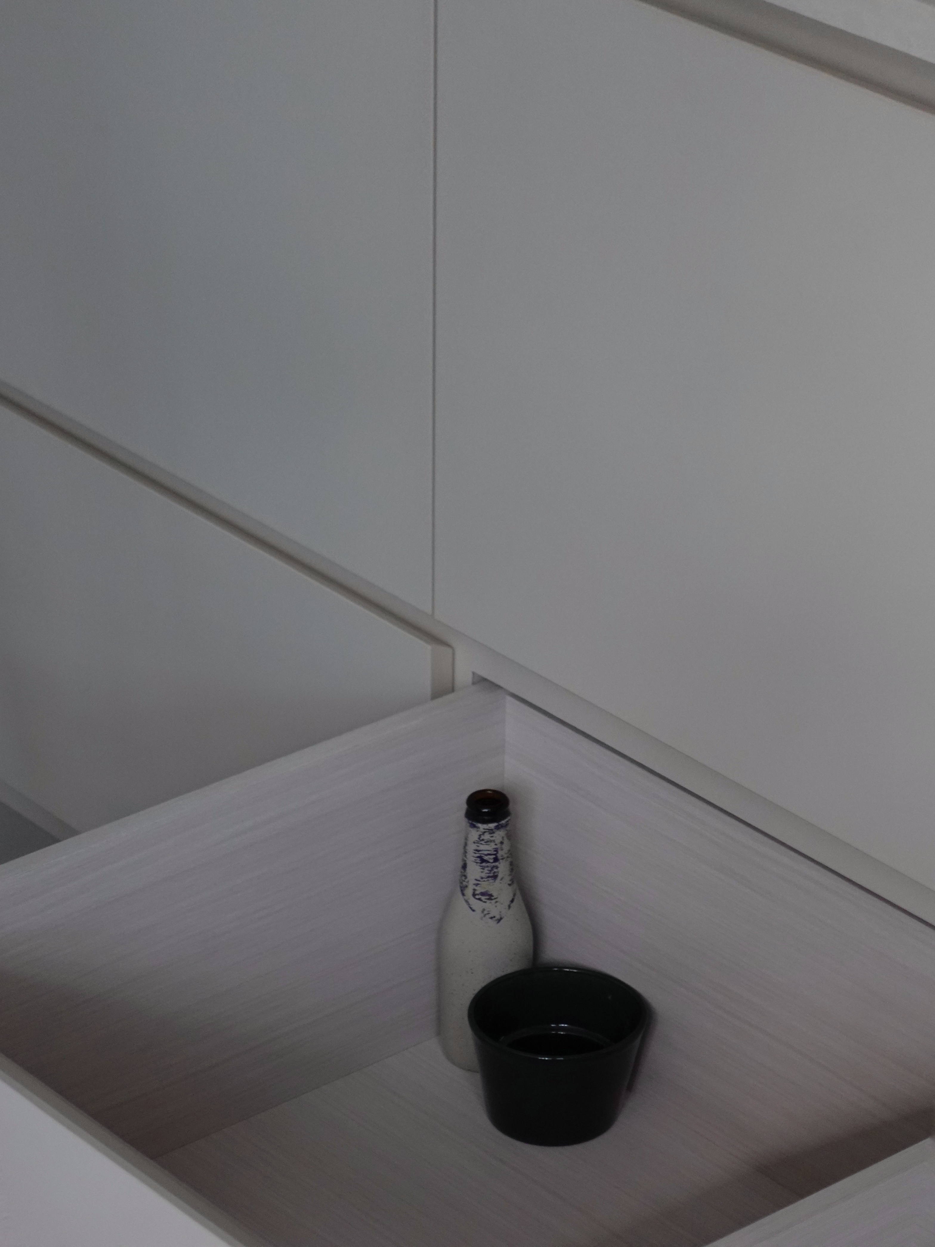 How we kept our dining room visually clutter-free - White bottle with blue patterns, black cup, minimalist interior
