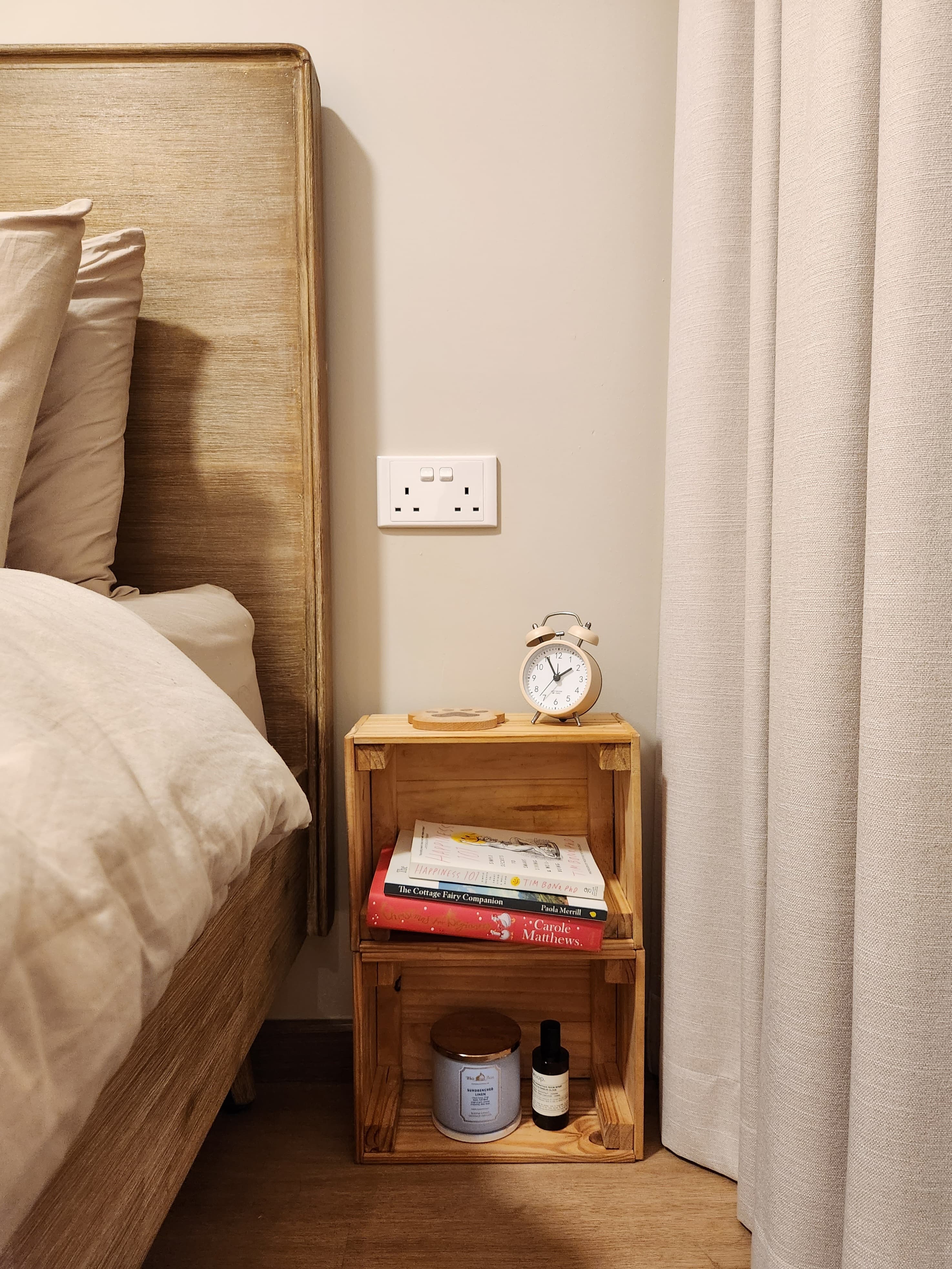 Restful Retreat in Our Neutral-Toned Master Bedroom - Wooden nightstand, beige curtains, bedside table, books, alarm clock