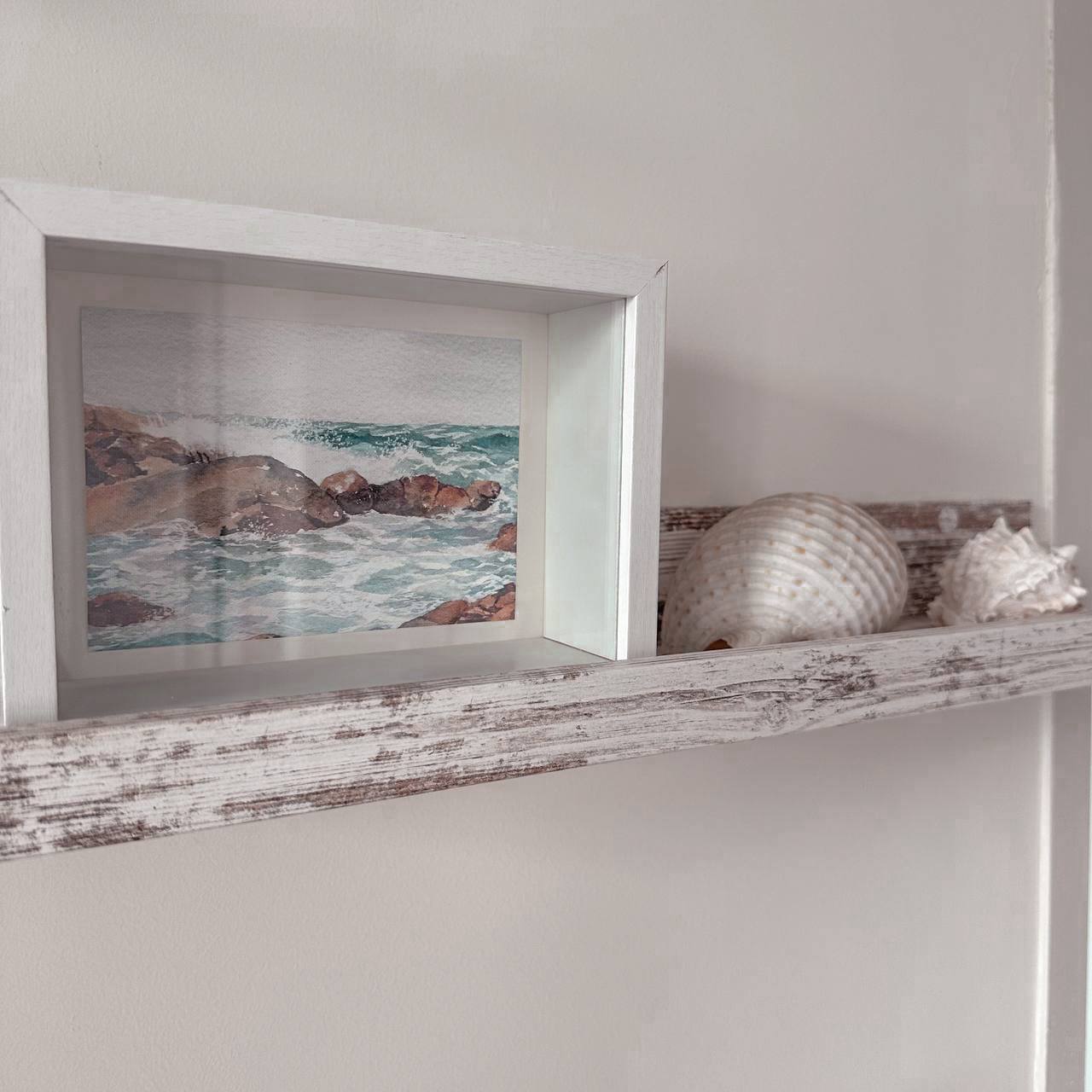 Beach Inspired Dining Space - Coastal seascape painting on white frame, Seashells on rustic shelf, Natural beach scene