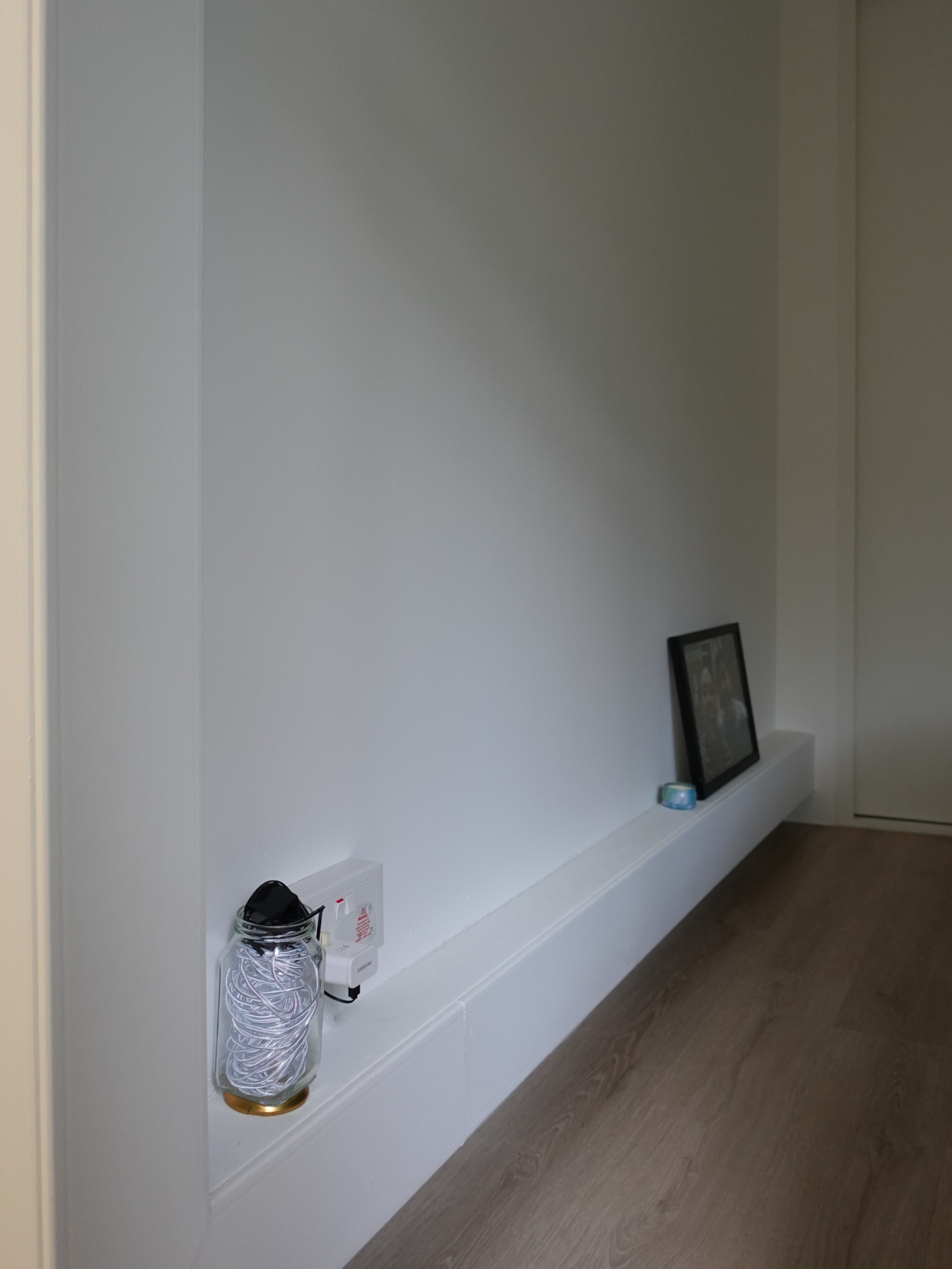 A minimal bedroom with a wardrobe that you’ve never seen before - Glass jar with coiled white cord, white shelf, wooden