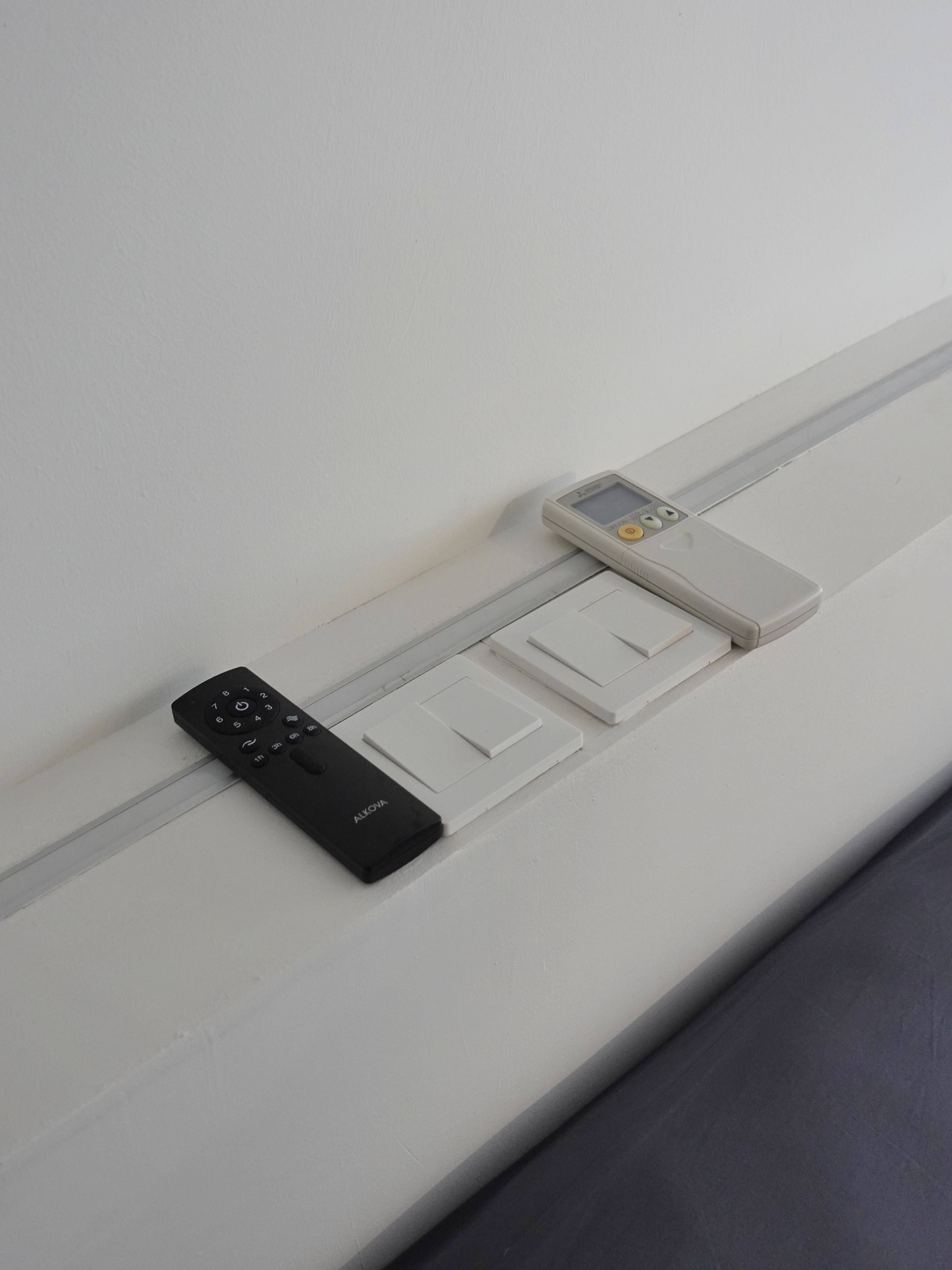 A minimal bedroom with a wardrobe that you’ve never seen before - Remote control, digital display, control buttons, black and