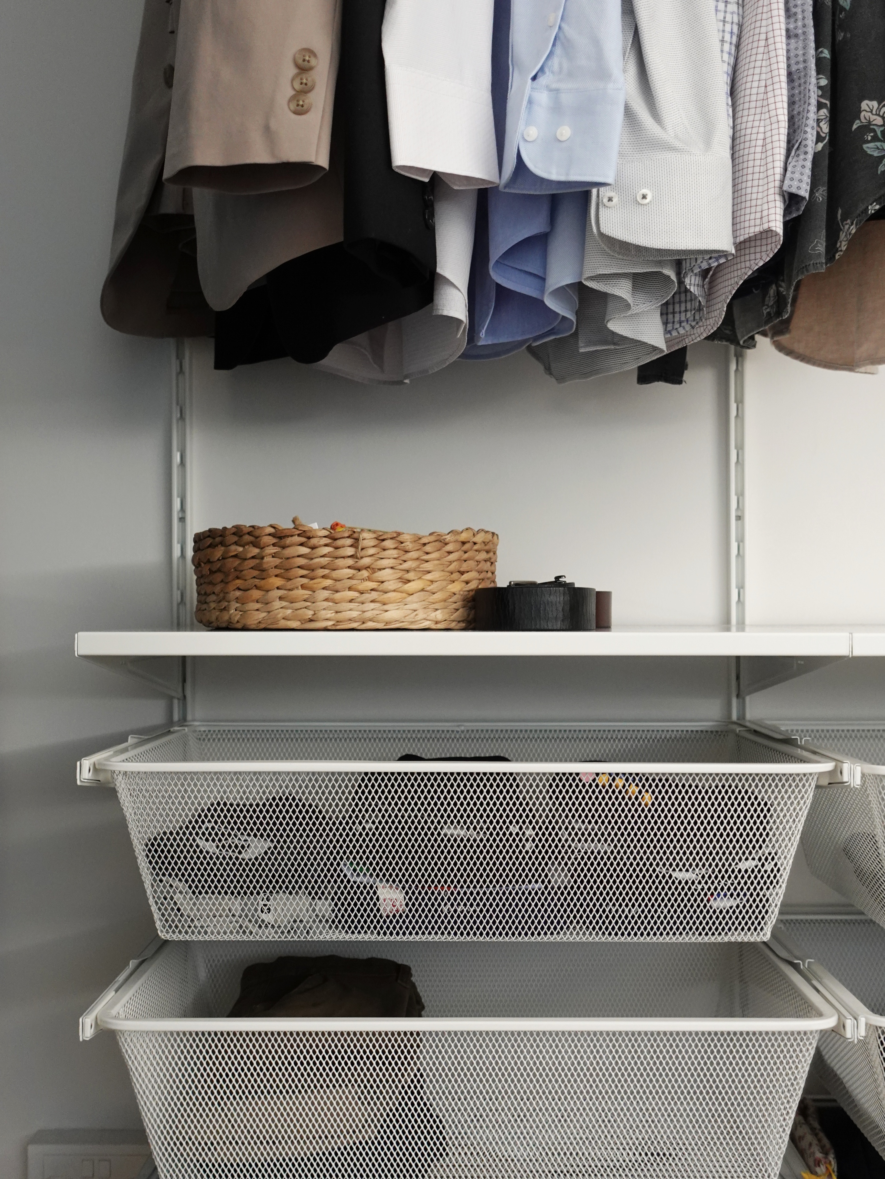 A minimal bedroom with a wardrobe that you’ve never seen before - Organized closet with neatly hung clothes, white shelves