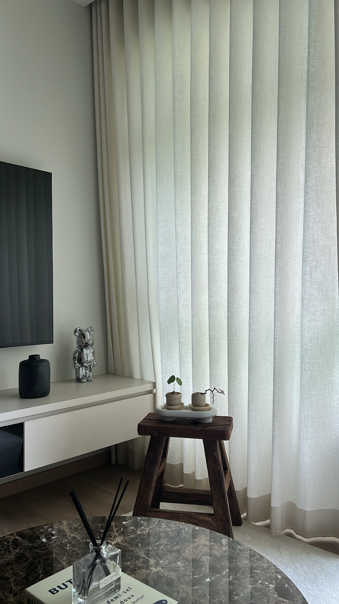 Some home decor tips! - Modern minimalist living room, sleek TV stand, abstract sculpture, soft natural light, light-colored