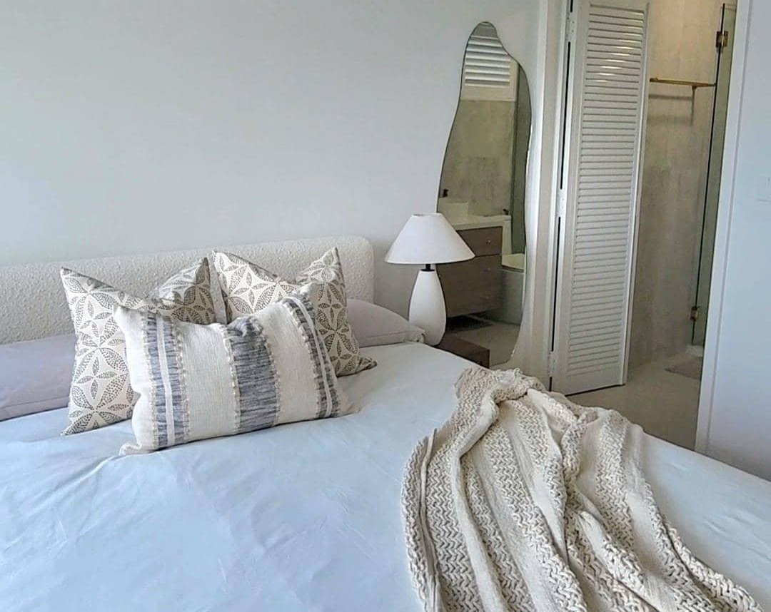 Master Bedroom - Simplicity in slumber - White and beige patterned pillows, white bedspread, cozy blanket, modern bedside