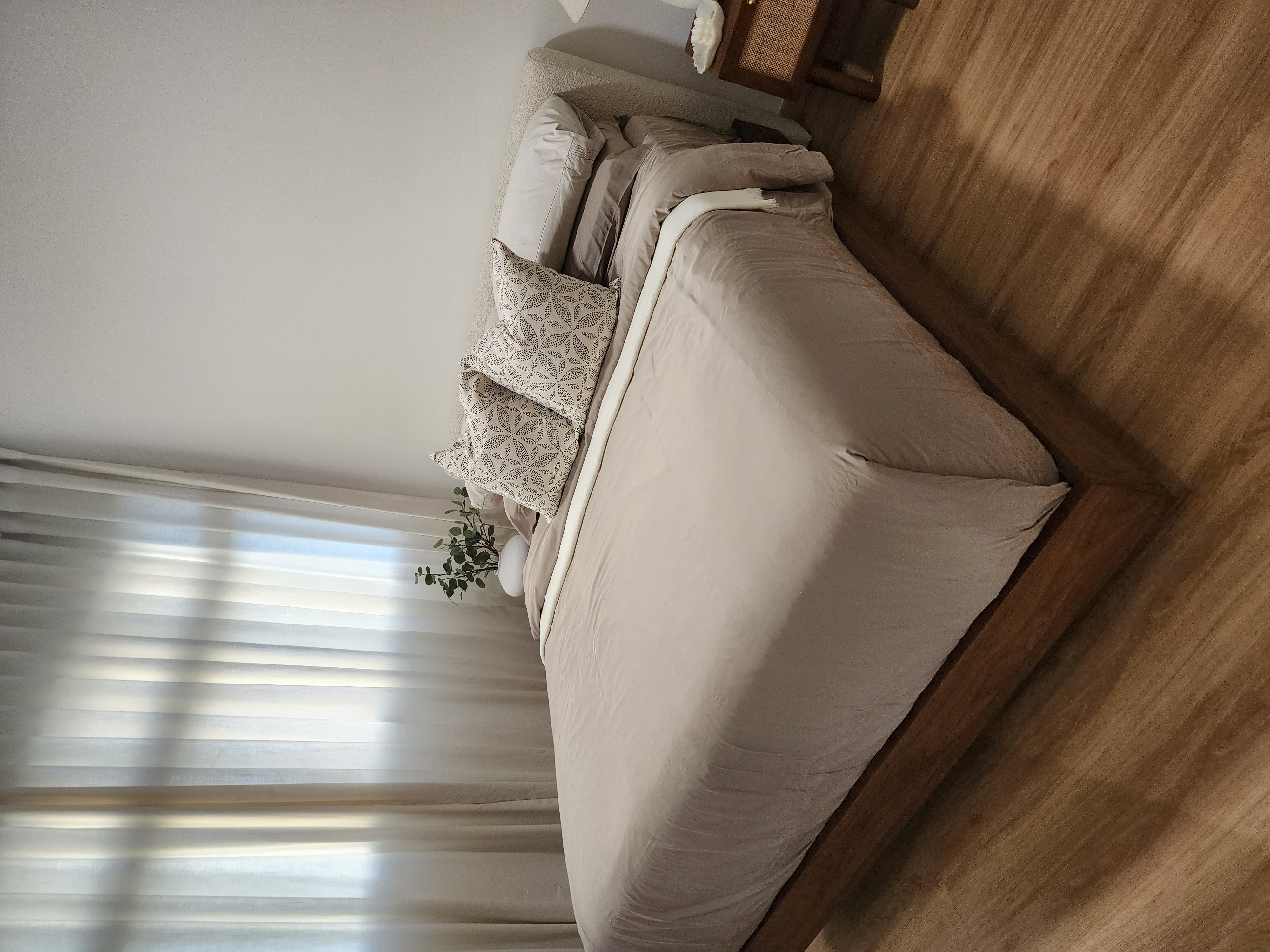 Master Bedroom - Simplicity in slumber - Light beige bedding, wooden floor, sheer white curtains, natural light streaming