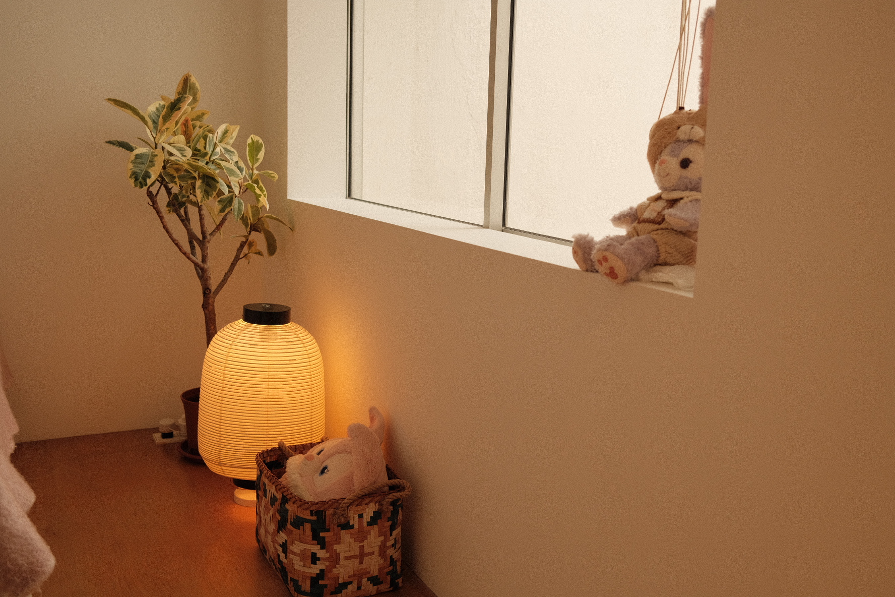 Our compact bedroom layout and accessories  - Soft, cozy room, warm lighting, indoor setting, plush toys, basket, lantern