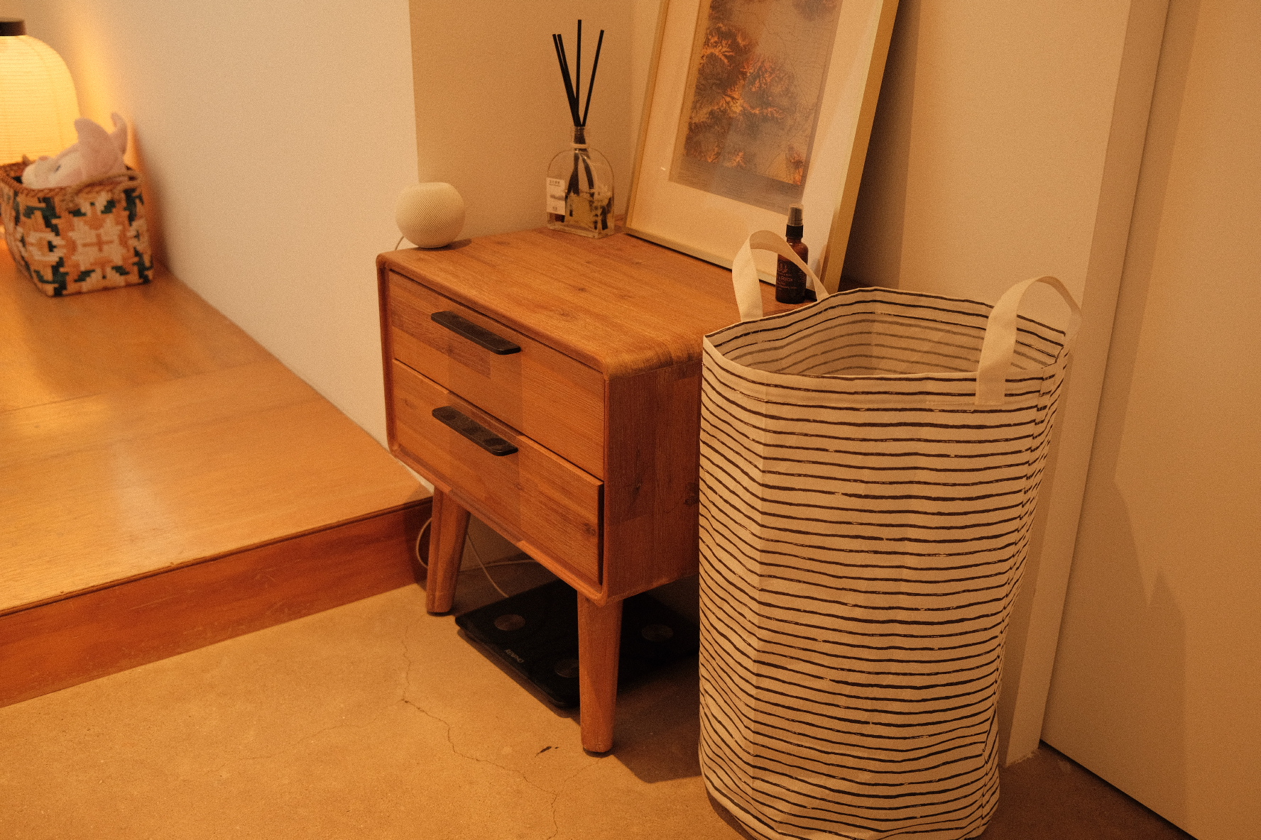 Our compact bedroom layout and accessories  - Wooden side table, striped bag, wooden dresser, small lamp, decorative rabbit
