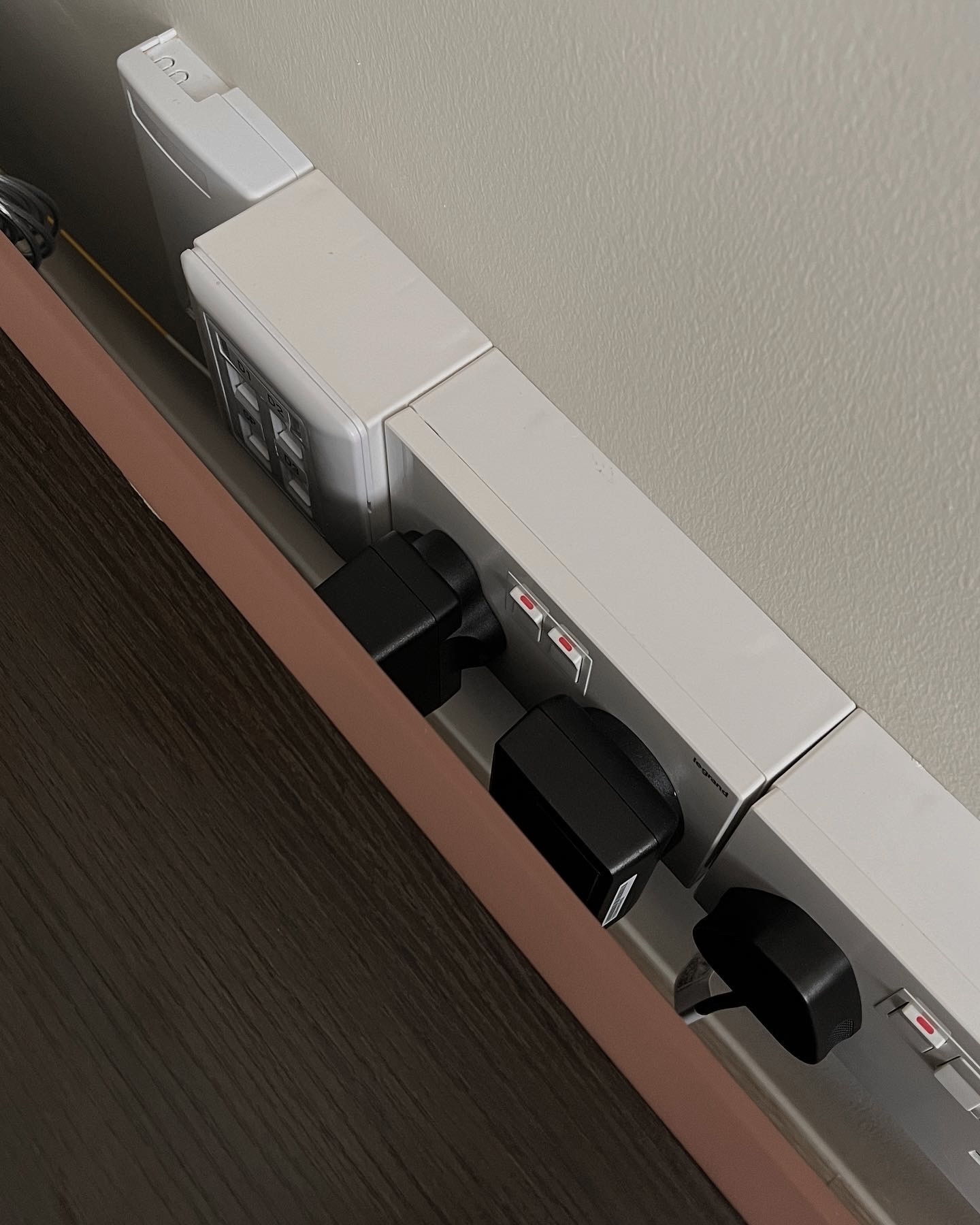 Living Space: our favourite spot at home - Wall-mounted power strip, dual outlets, black power plugs, gray wall outlet