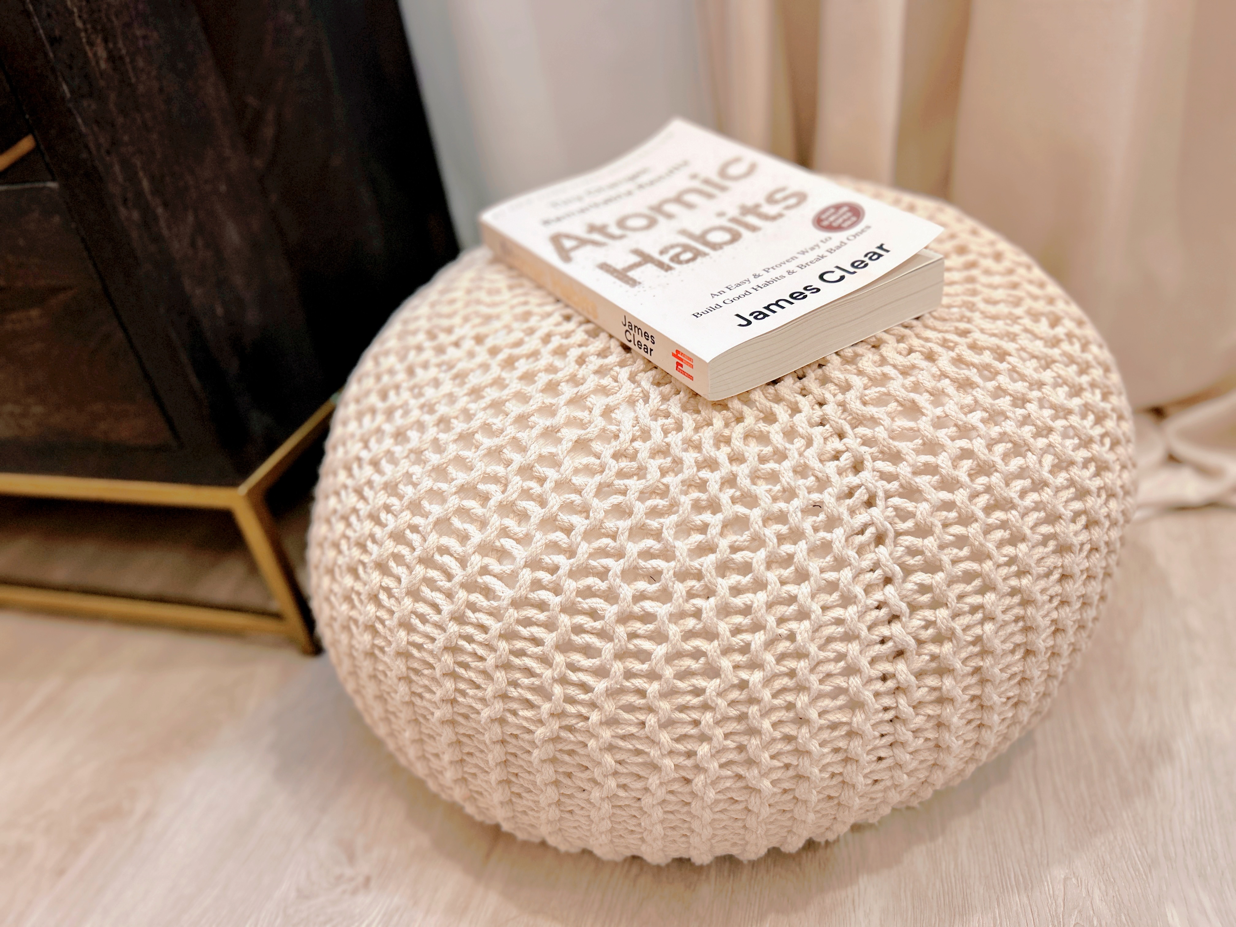 Welcome to our tranquil bedroom sanctuary, where relaxation awaits! - Cushion, knitted, beige, round, book, "Atomic Habits, "