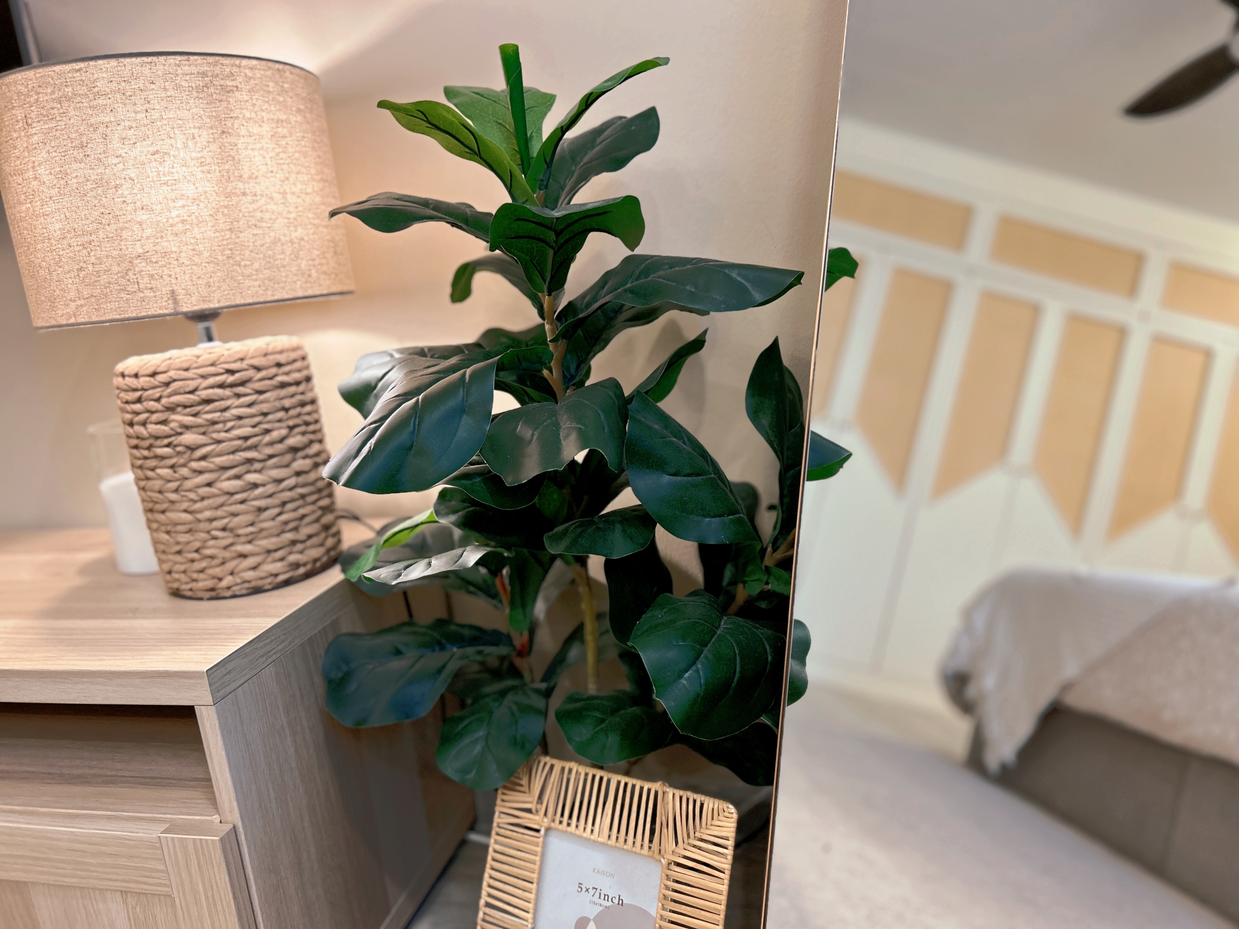 Welcome to our tranquil bedroom sanctuary, where relaxation awaits! - Lavender-leaved plant, wooden dresser, beige lampshade