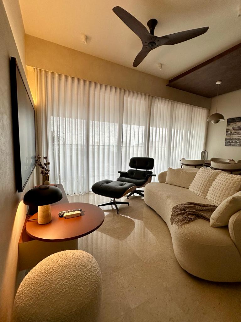 Living room - the space with the most complexity - Modern living room with beige sofa, black office chair, round coffee
